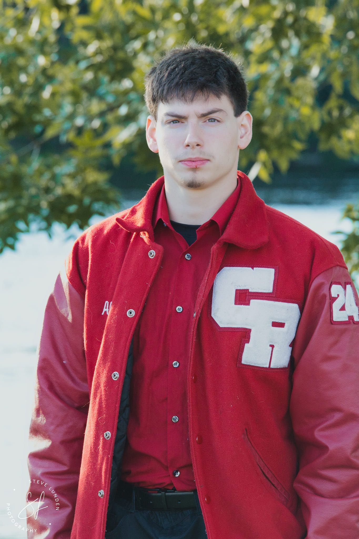 teenage boy posing in varsity jacket