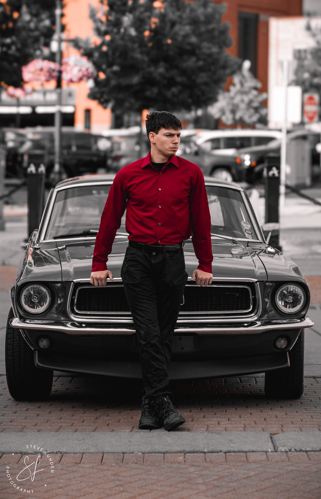 teenage boy posing in front of sportscar