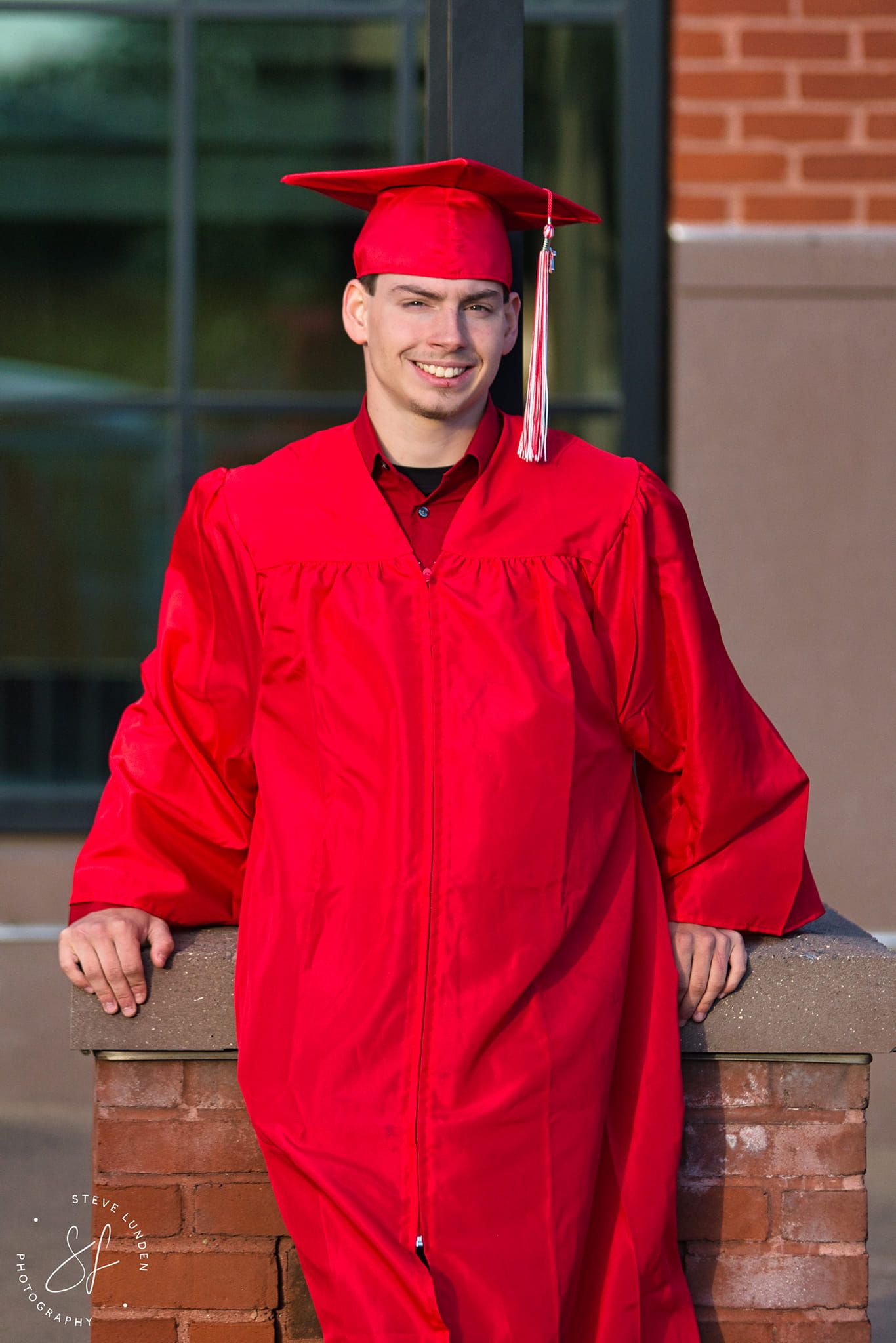 teenage boy posing in graduation cap and gown