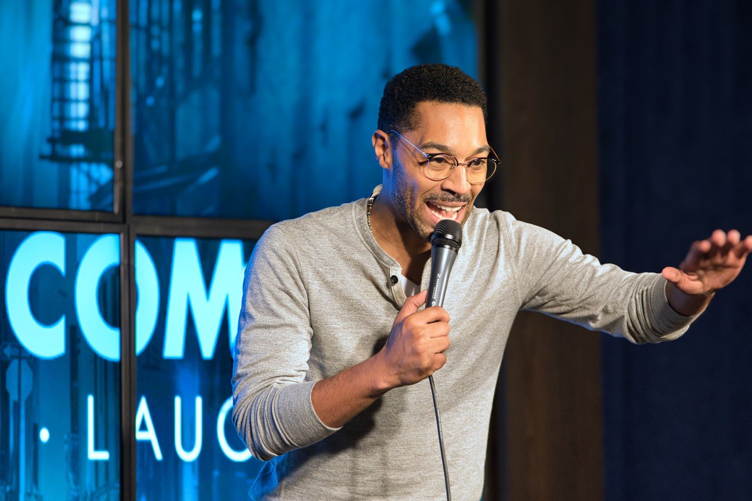 male comedian on stage telling a joke