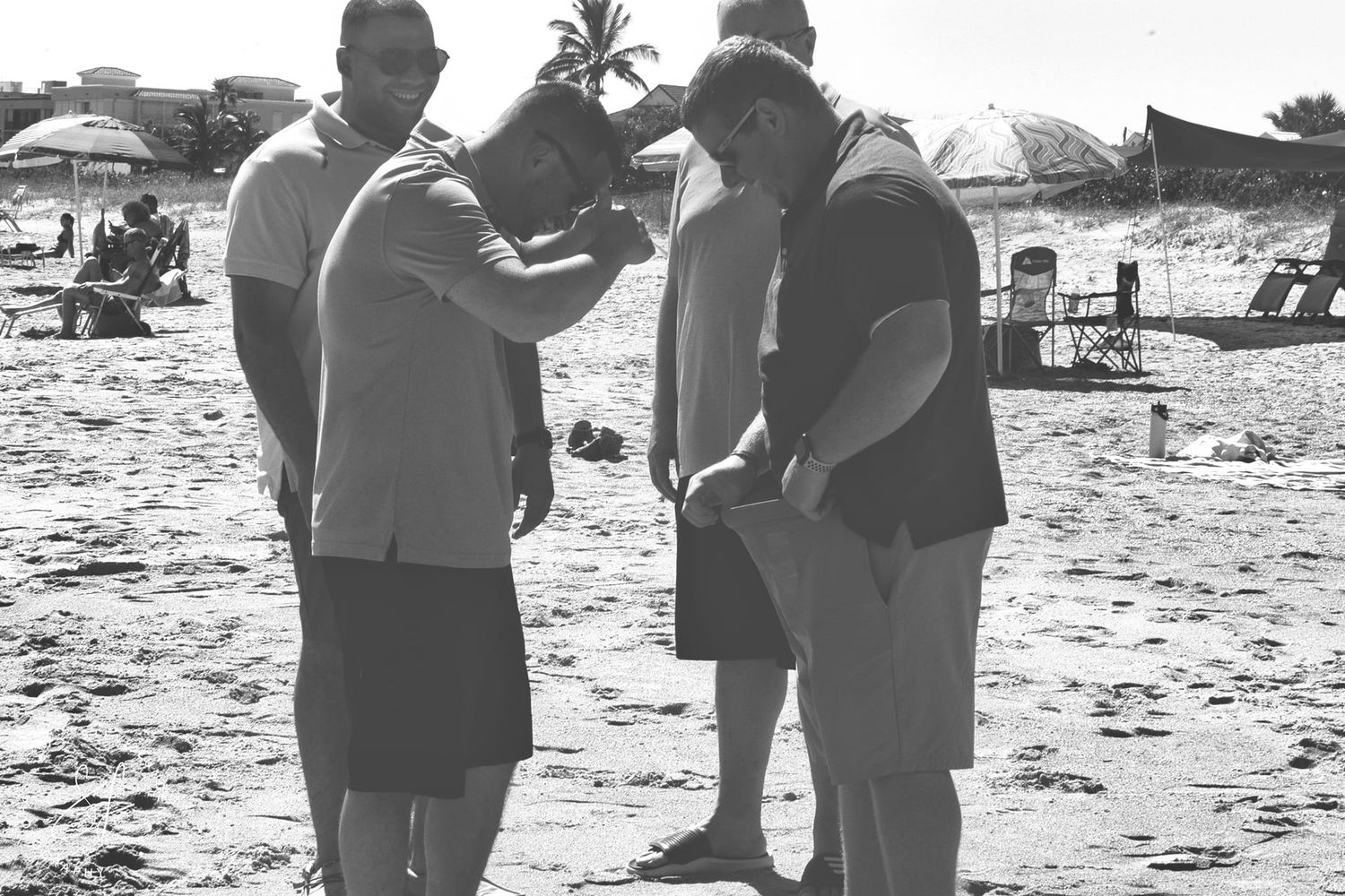 4 men laughing as one pulls out shorts