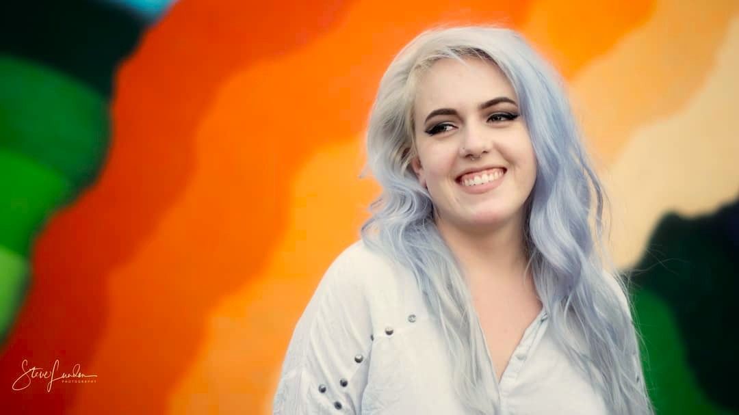 potrait of a young woman in front of a colorful wall