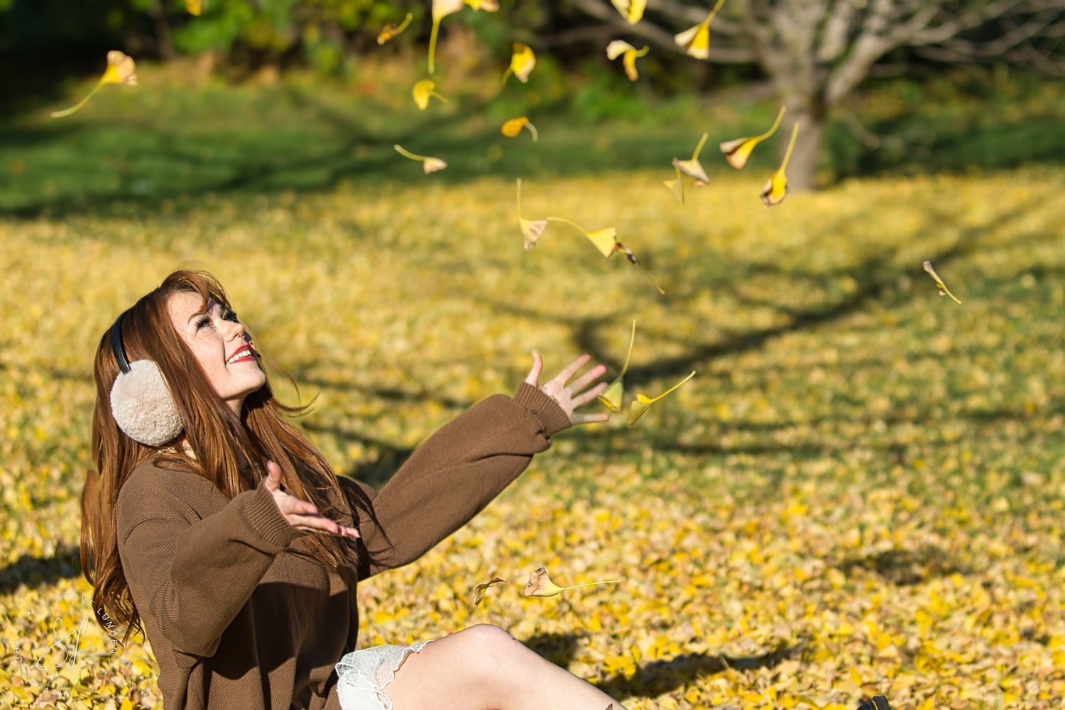 teenage girl playing in the fallen leaves