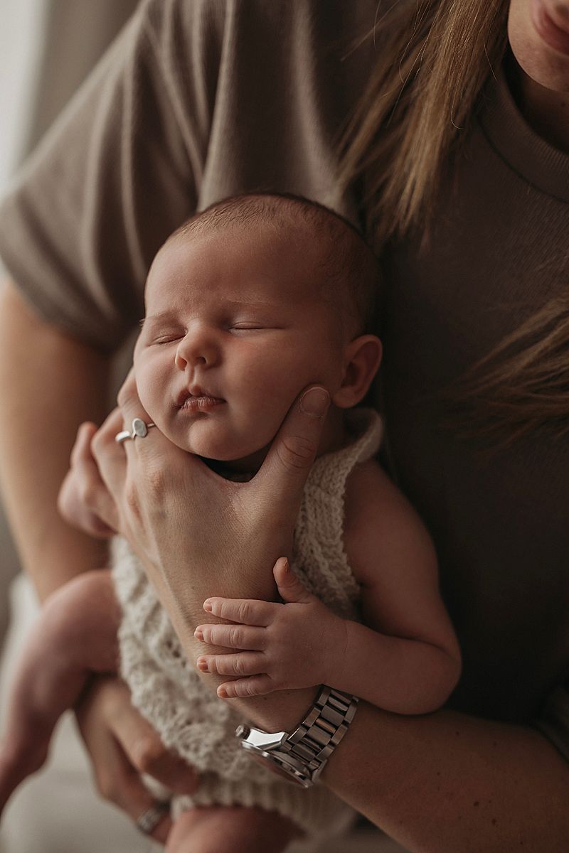 newborn baby boy sleeping in dads arms, cosy and loved for his newborn photo session