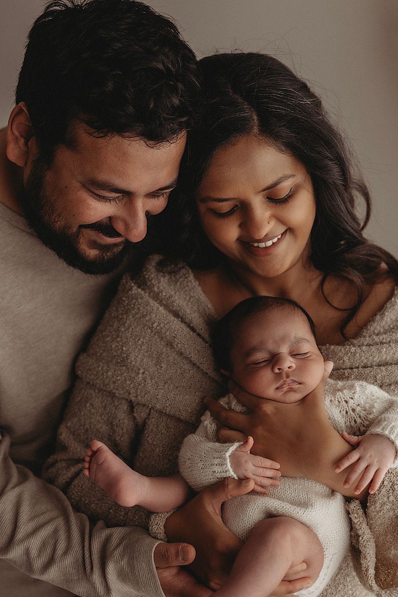 new parents holding sleeping baby in geelong newborn photographer studio