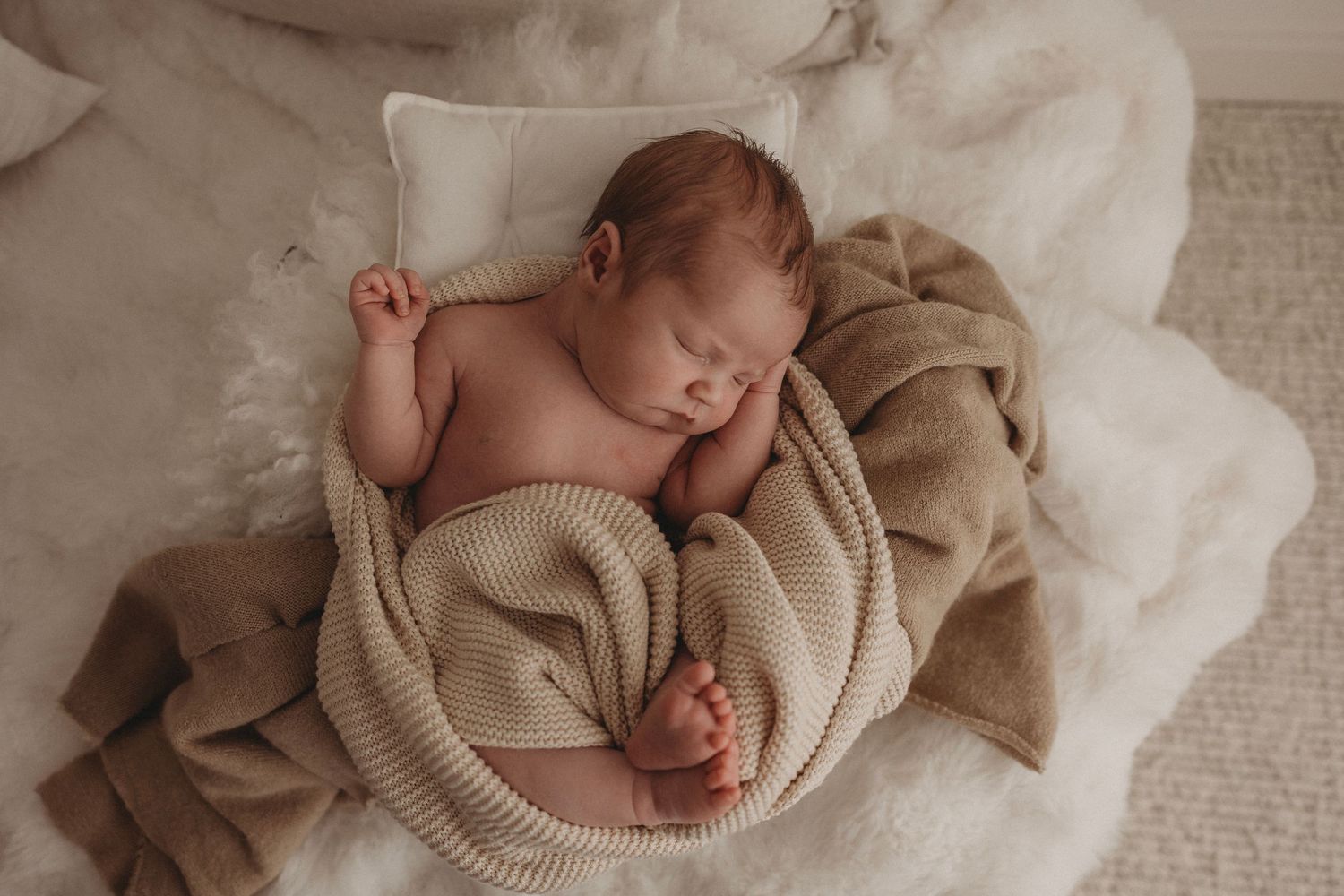 newborn baby in beige blanket, snuggled up sleeping, ready for a newborn photography session in Geelong