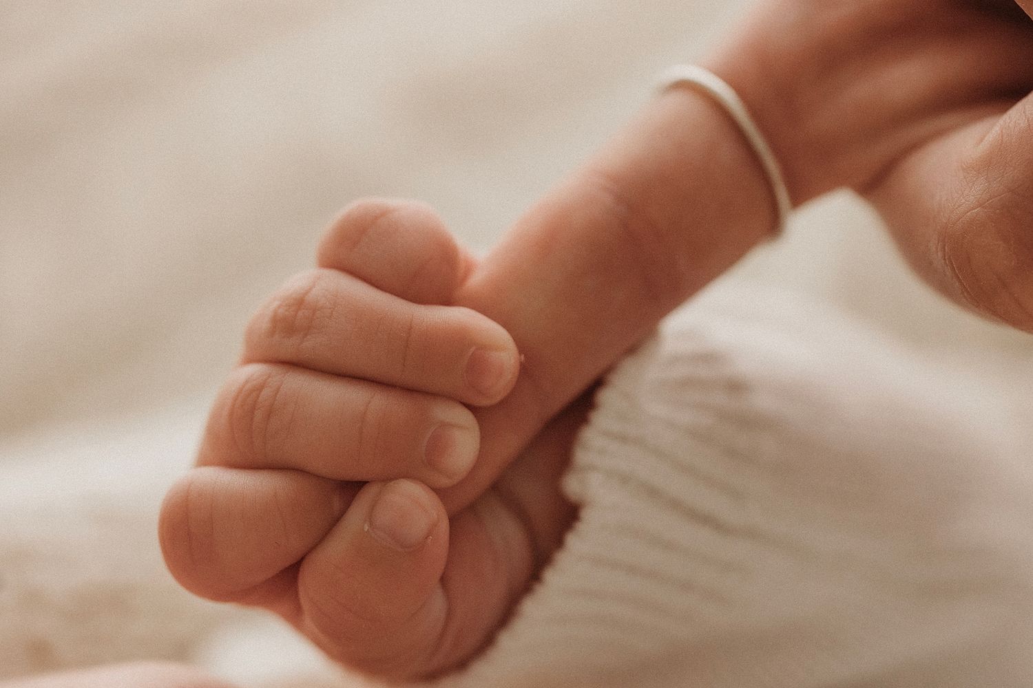 Baby gently holding Mum’s finger during a natural family photography session in Geelong.