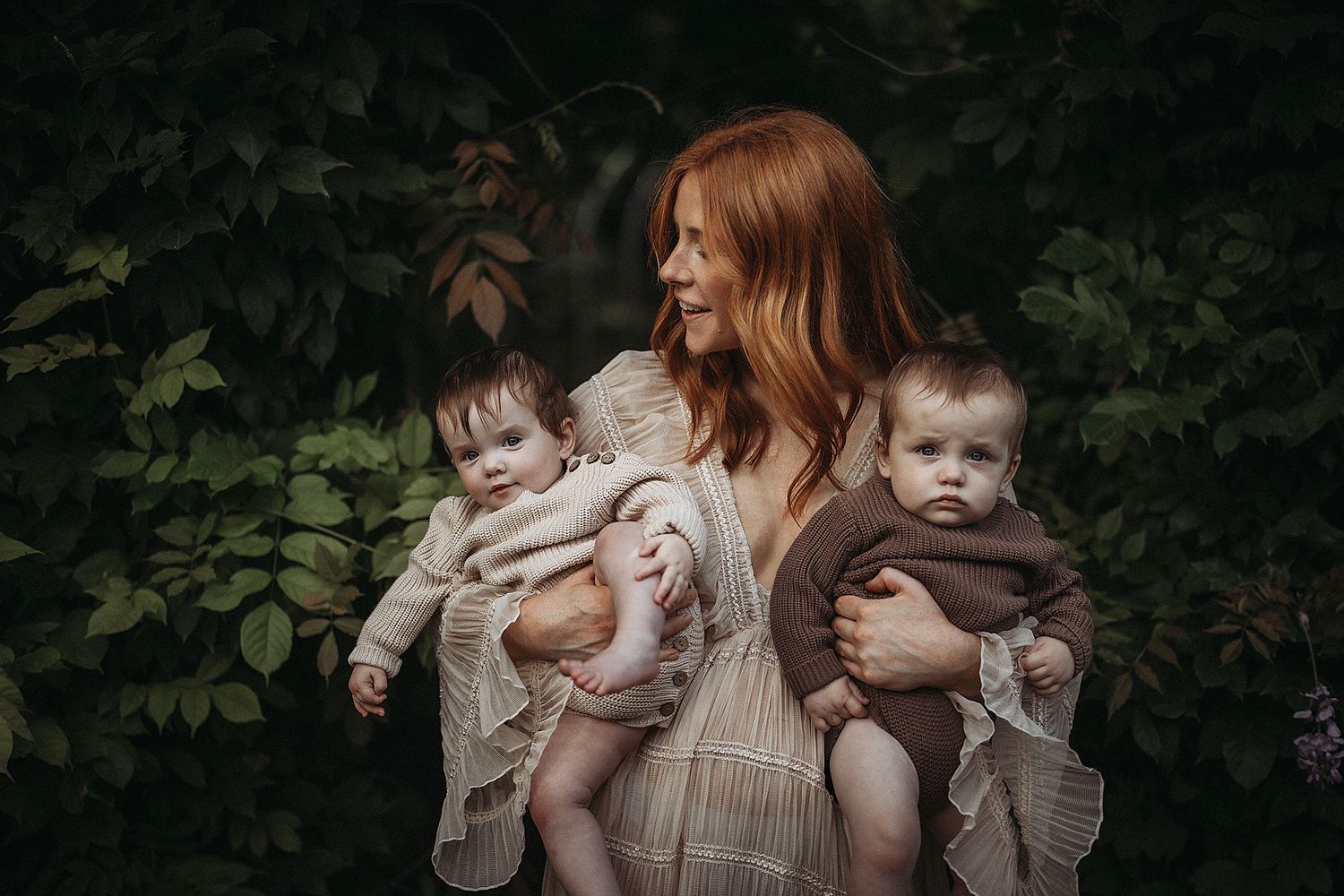 Intimate motherhood photograph of a mum cuddling her twin babies, focusing on closeness, emotion, and bonding