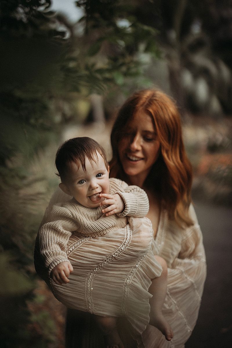 Motherhood session featuring a mum comforting her twin babies, photographed in a minimal, neutral studio setting
