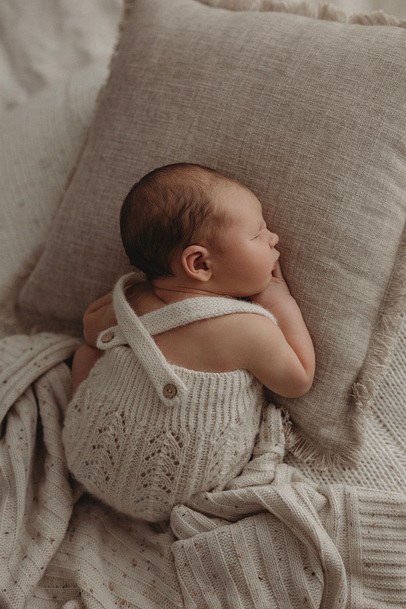 sleeping-baby-curled-up-in-basket-with-lots-of-knit-layers