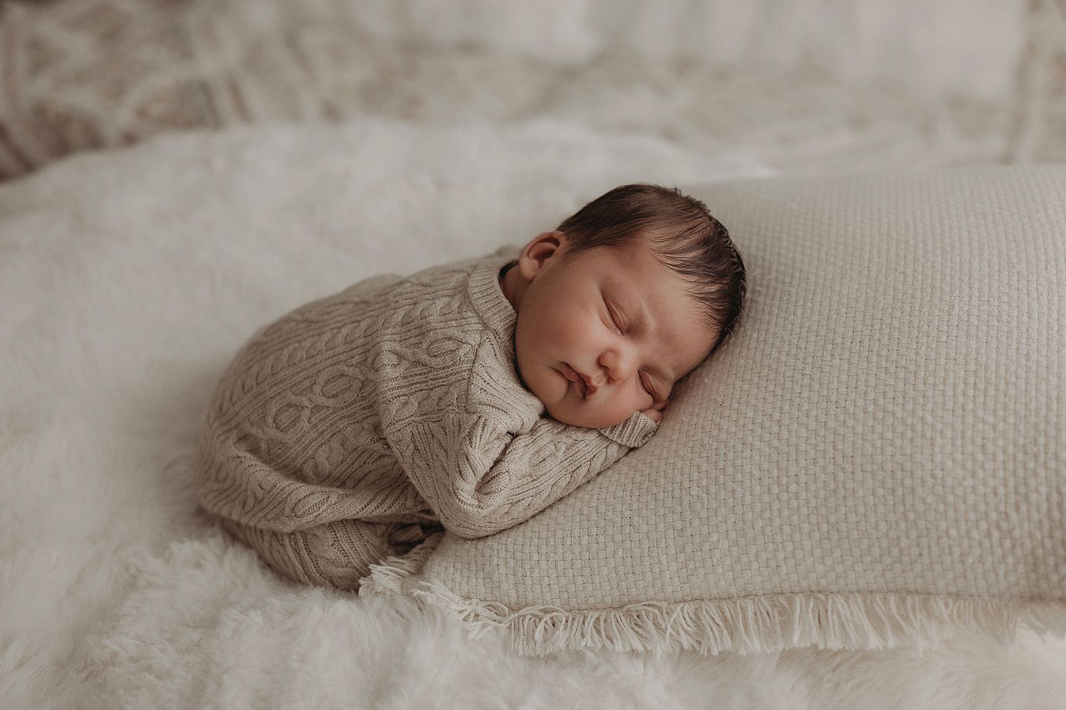 Newborn baby sleeping in a brown knit romper during geelong photoshoot