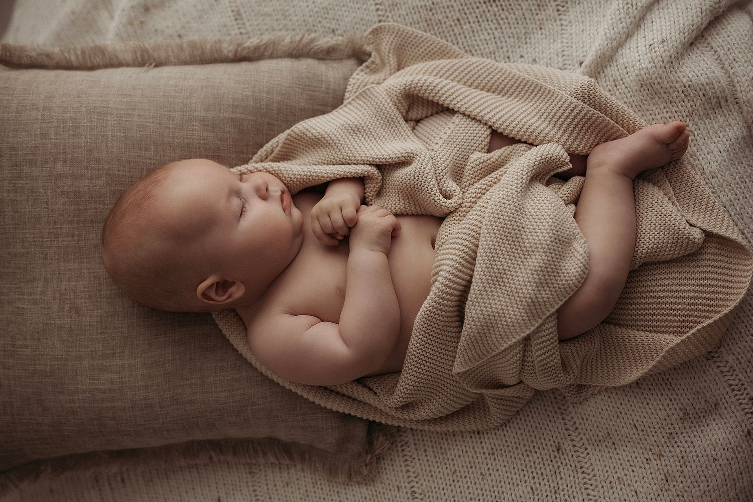 Sleeping baby in a brown knit blanket during a photoshoot in geelong