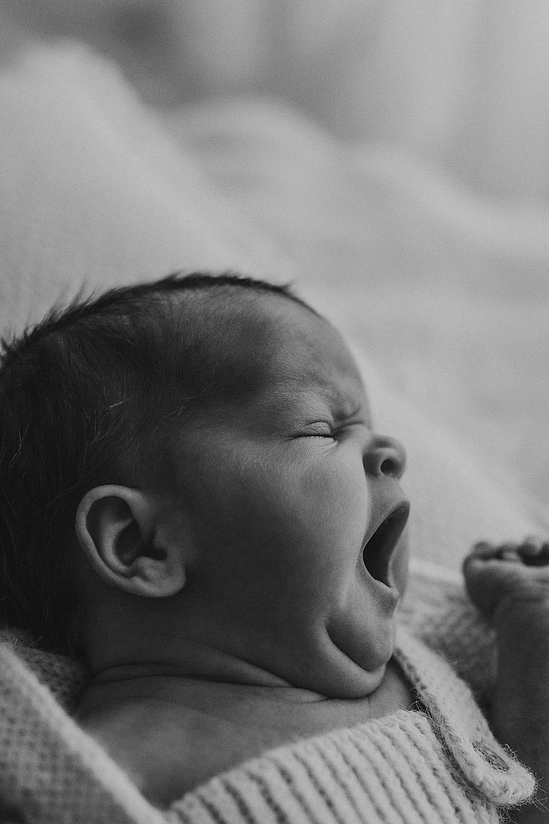 sleepy newborn yawning in photography studio geelong