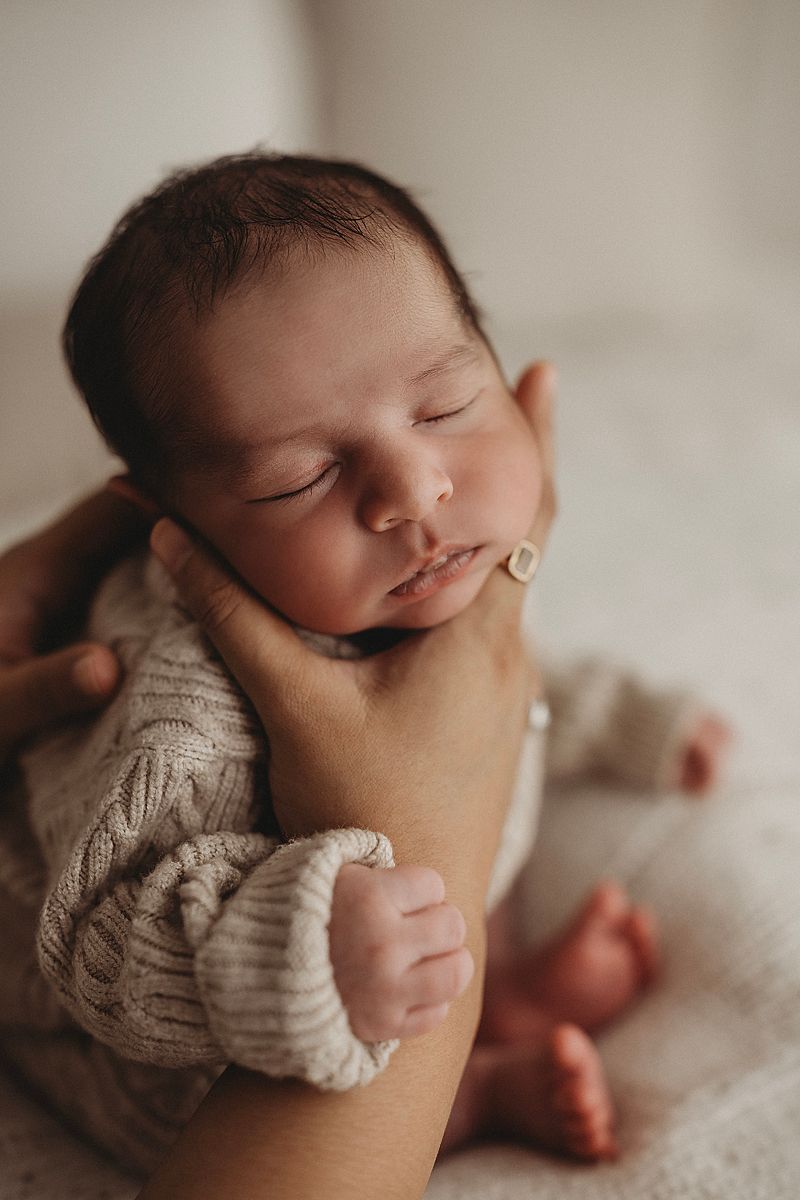 baby snuggled in mums hands in geelong photography studio