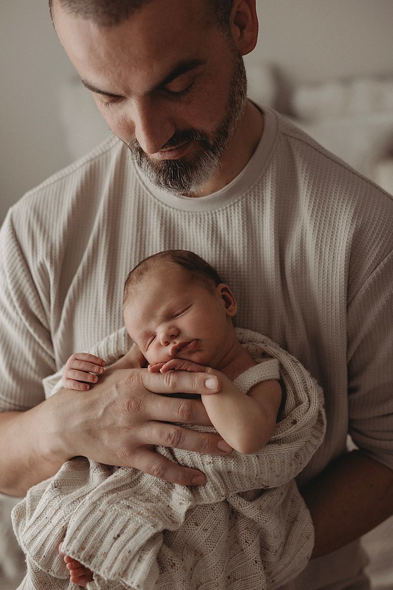 first-time-dad-holding-sleeping-newborn-during-photoshoot-in-geelong