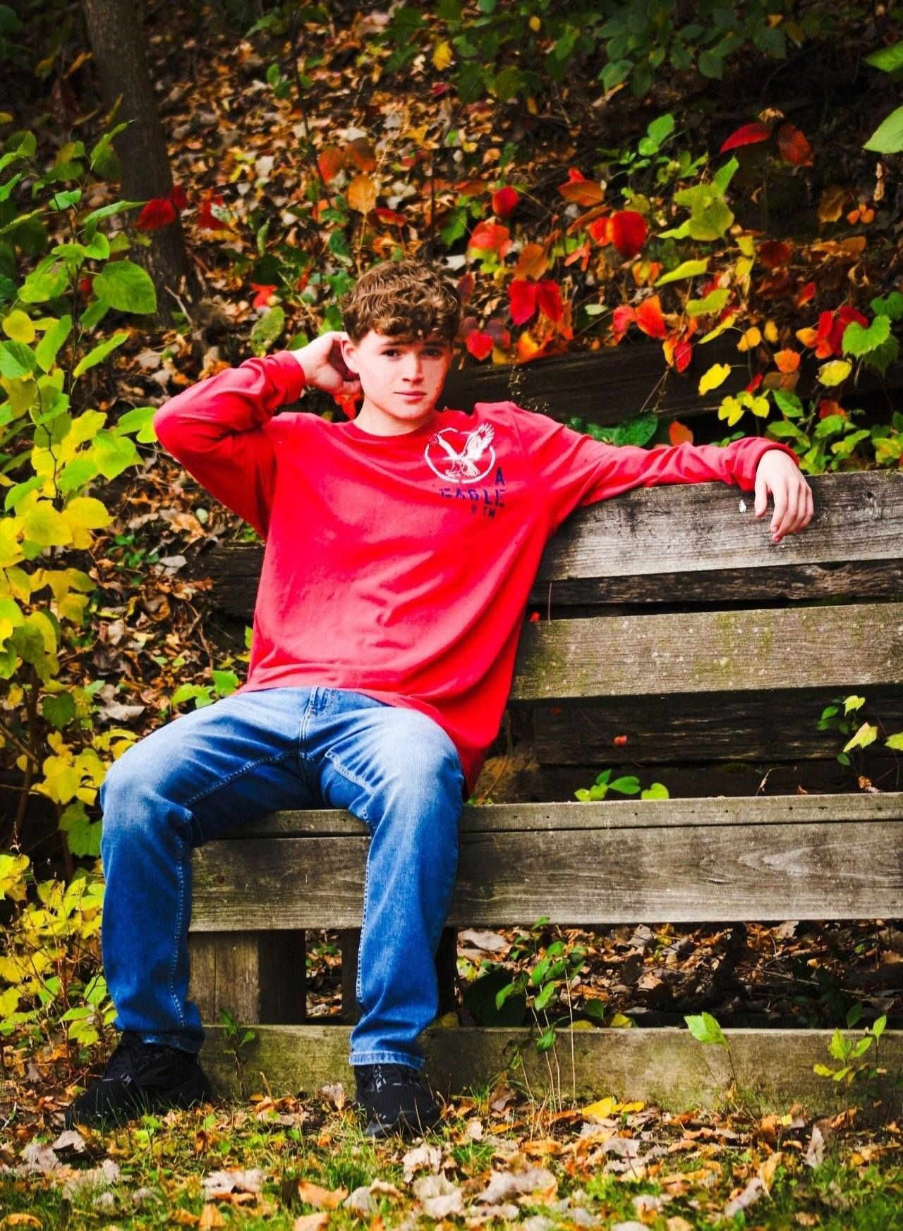 Senior portrait of male on wooden bench, Le Mars, Iowa