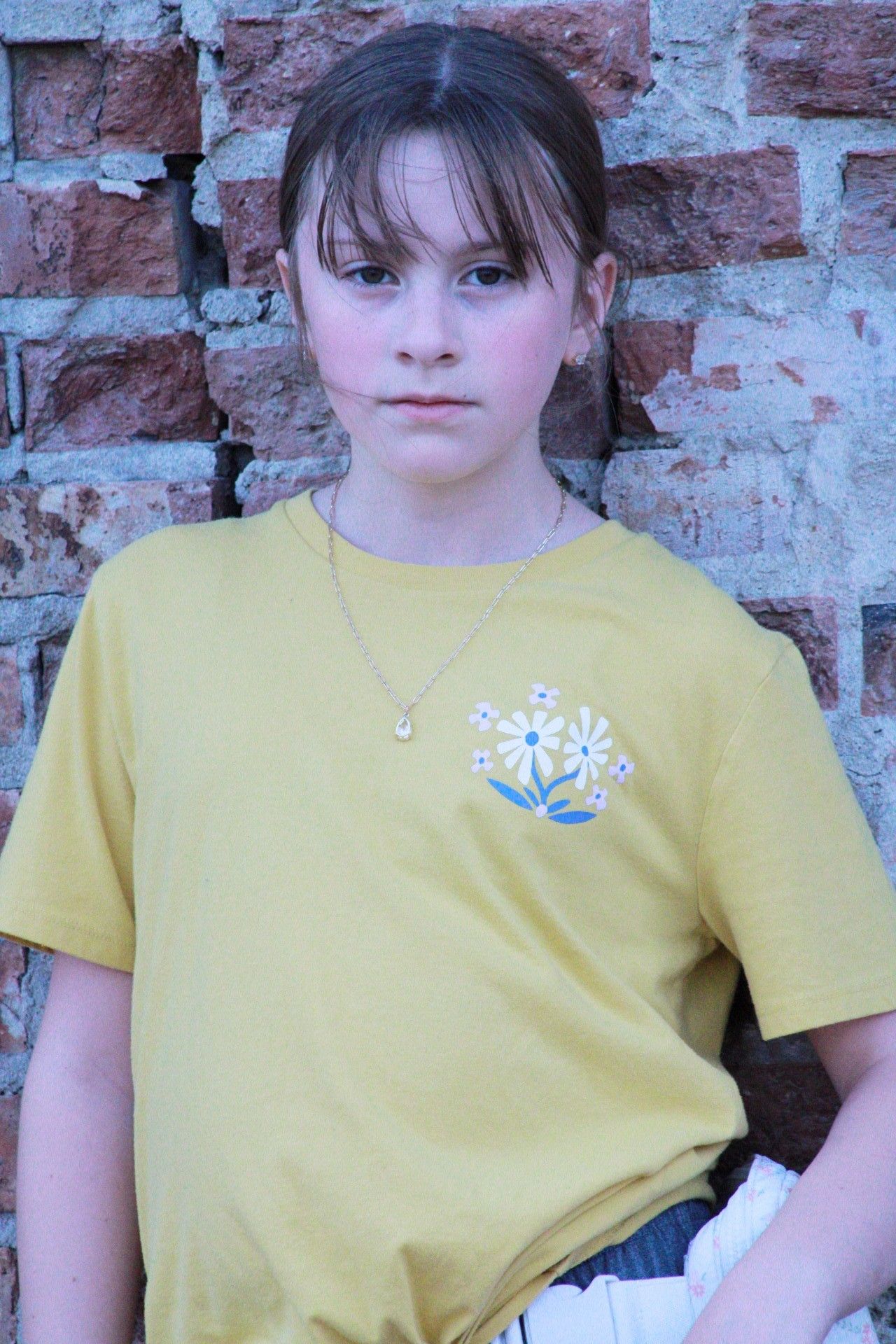 Portrait of female posing by brick wall, downtown Omaha, Nebraska