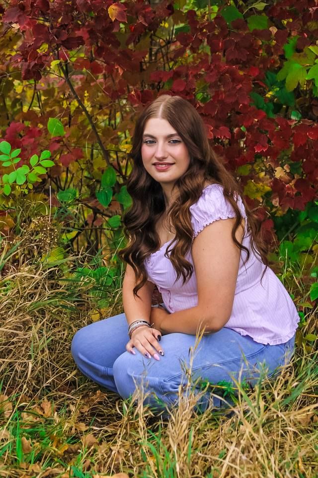 Senior portrait of female posing by fall foliage, Bacon Creek Park, Sioux City, Iowa