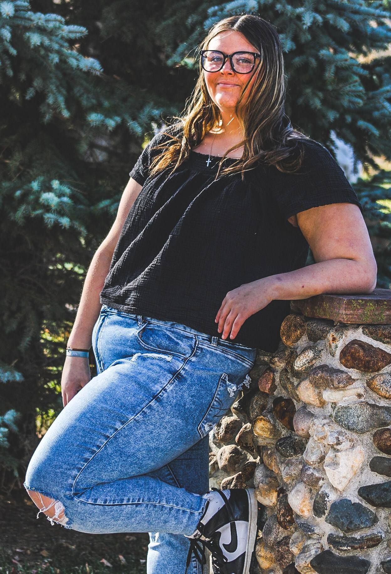 Senior portrait of female by stone wall, Trinity Heights, Sioux City, Iowa