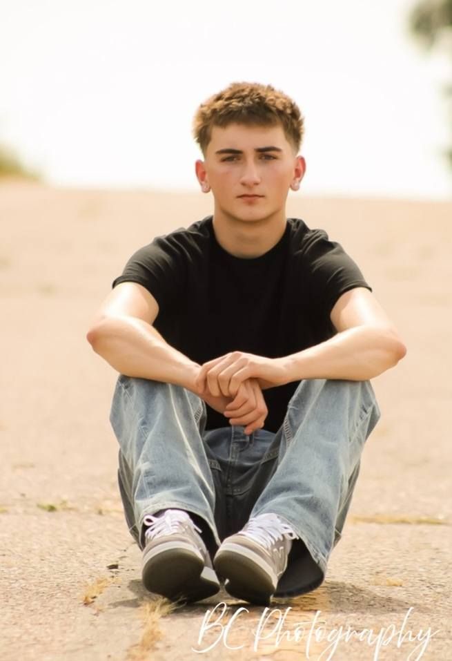 Senior portrait of male posing on roadway, outside Le Mars, Iowa