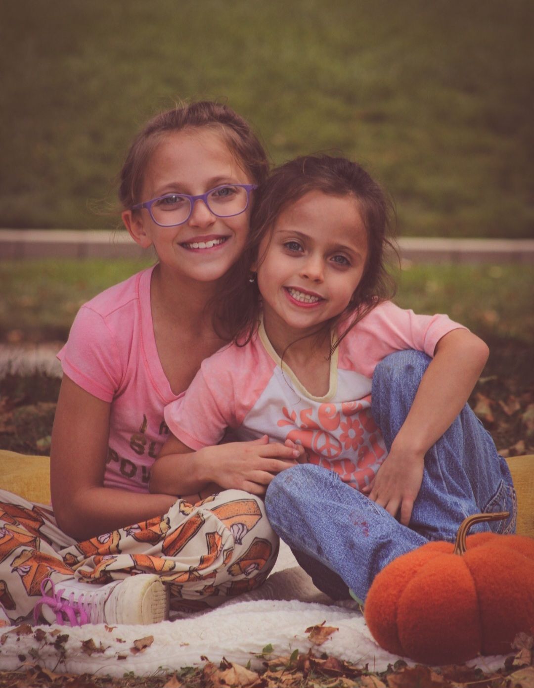 Two girls posing together on blanket in fall, Sioux City, Iowa