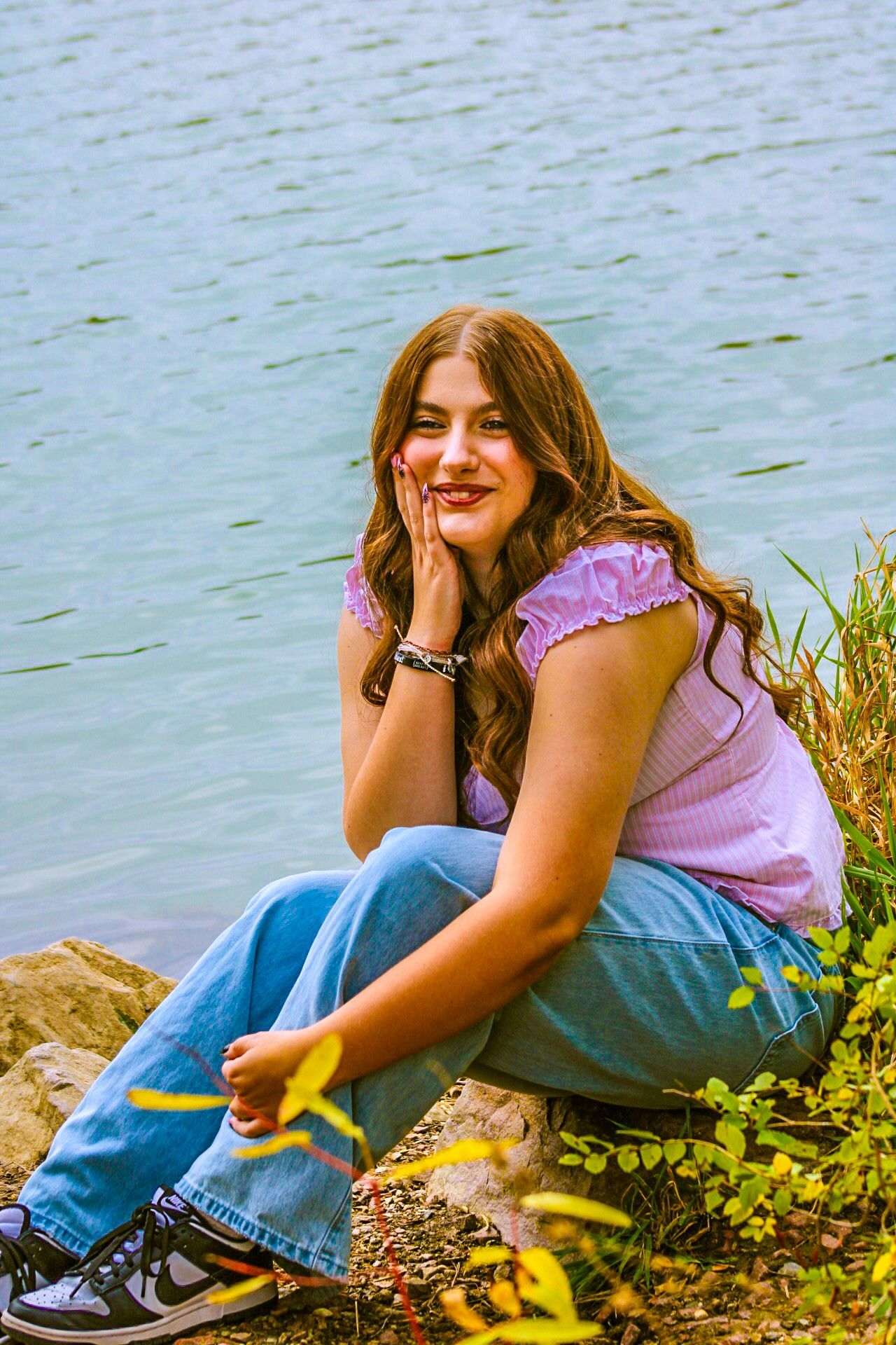 Senior portrait of female posing by rocks, Bacon Creek Park, Sioux City, Iowa