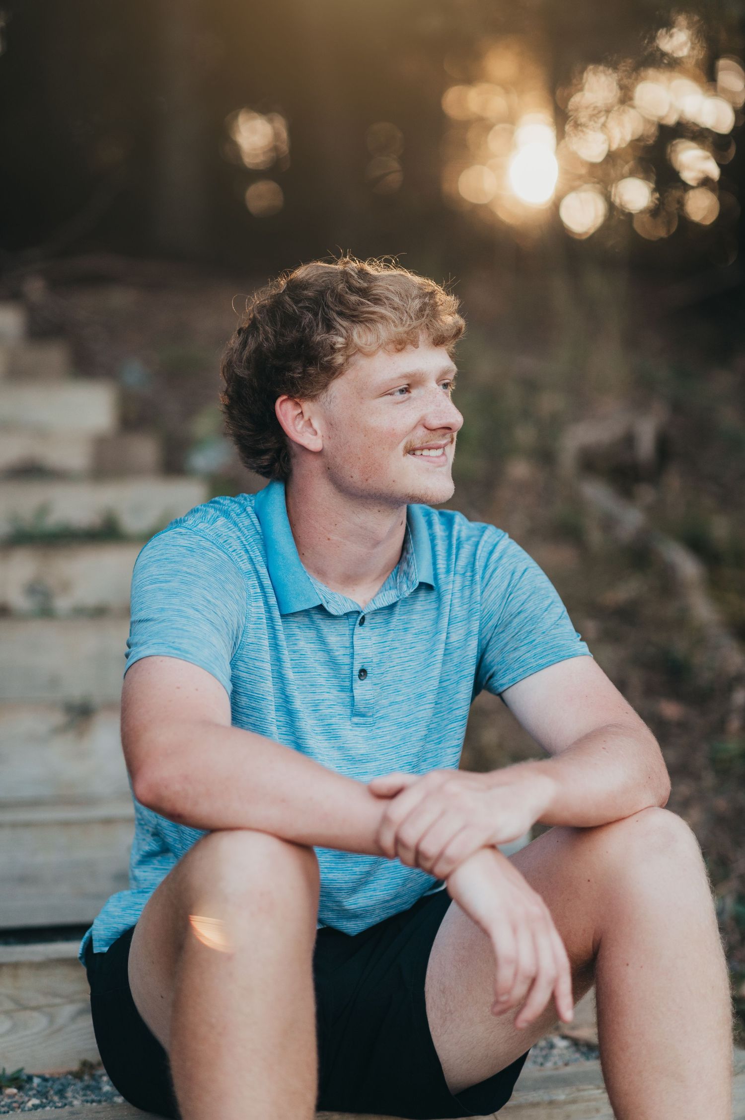 Casual outdoor portrait series during golden hour with teal polo shirt.