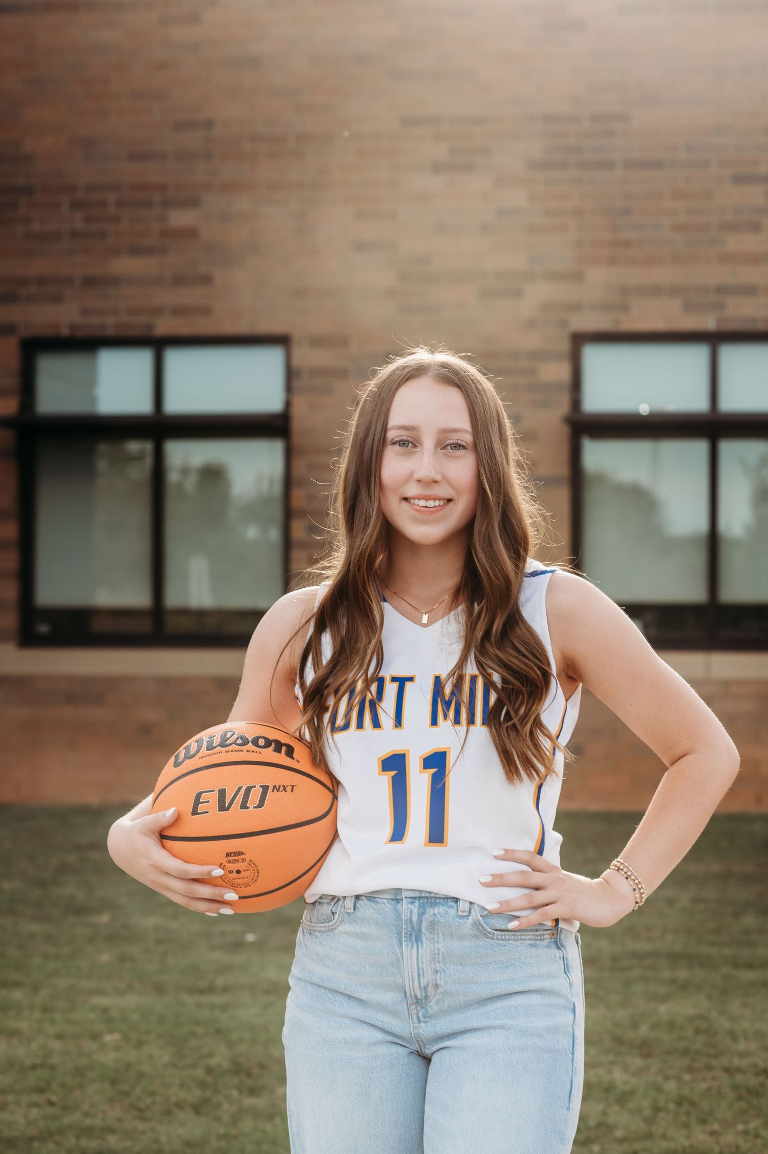 Basketball player poses with ball while wearing white Fort Mill jersey number 11.