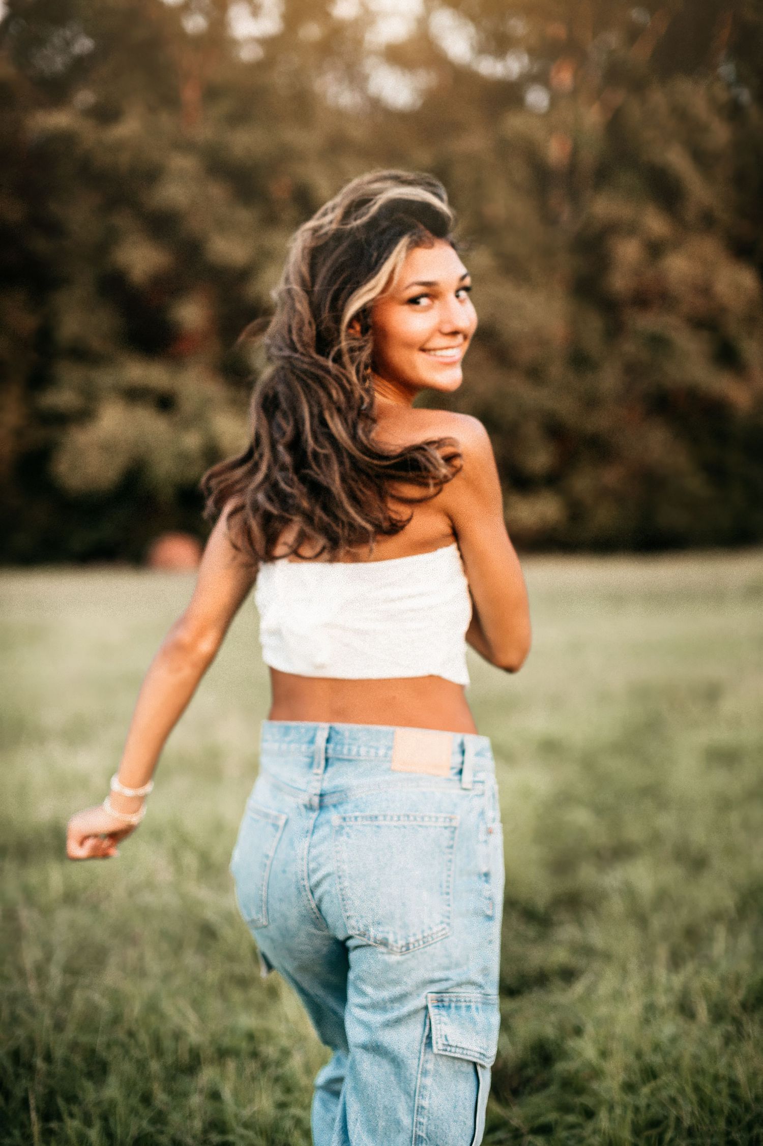 Playful outdoor portrait in white crop top and jeans during sunset. class of 2027 fort mill high school. Fort Mill, SC