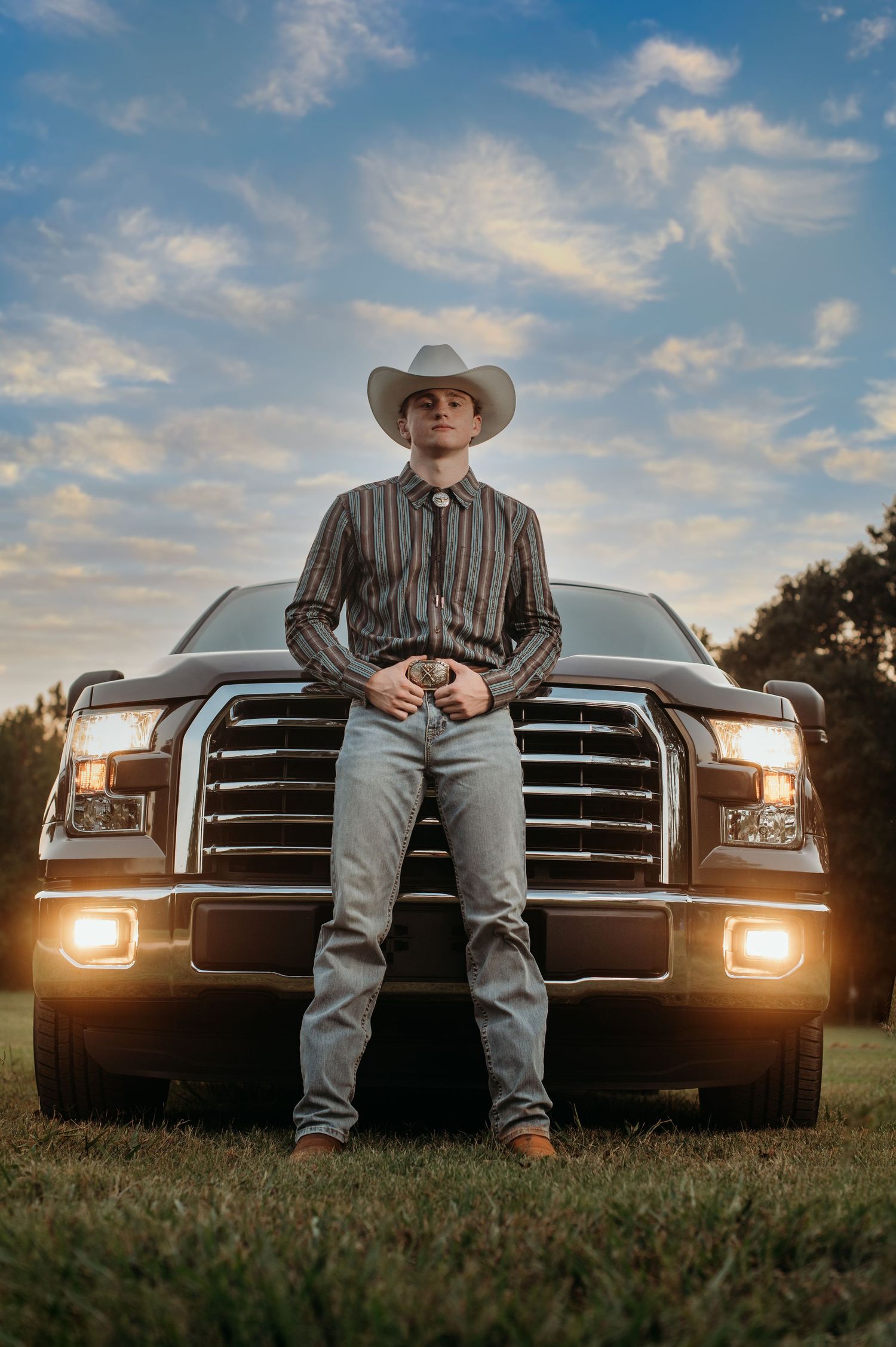 Sunset photoshoot with Ford truck featuring cowboy style and western aesthetic.