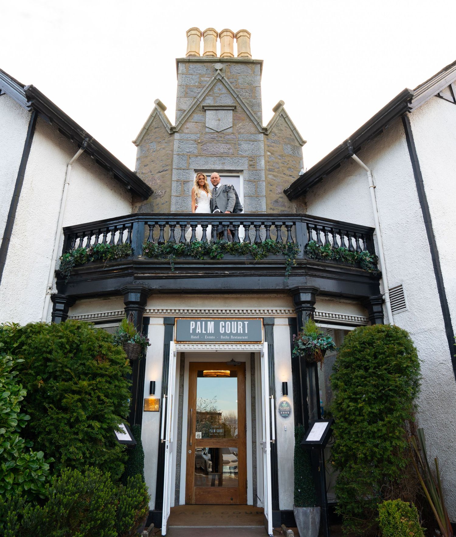 Exterior shot of a Victorian style house with a grand entrance featuring white walls and decorative architectural details.