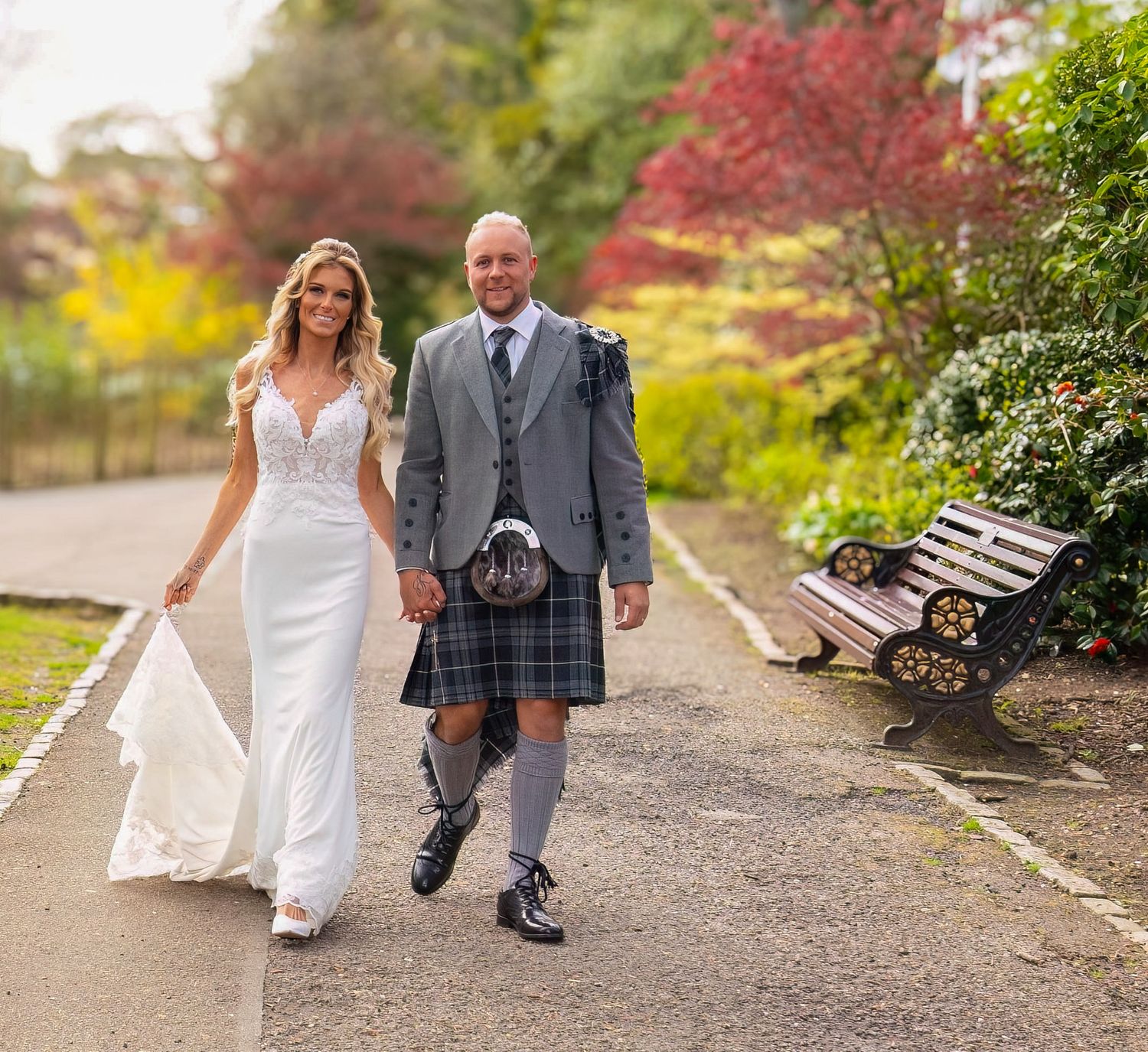 Couple walking together on outdoor garden path with autumn colors.