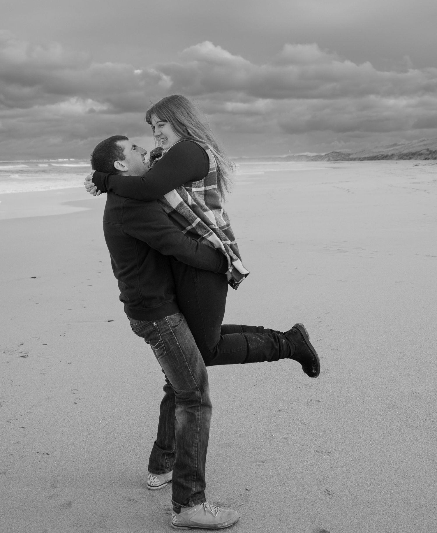 A sequence of beach photos showing a couple playfully spinning and dancing together by the ocean.