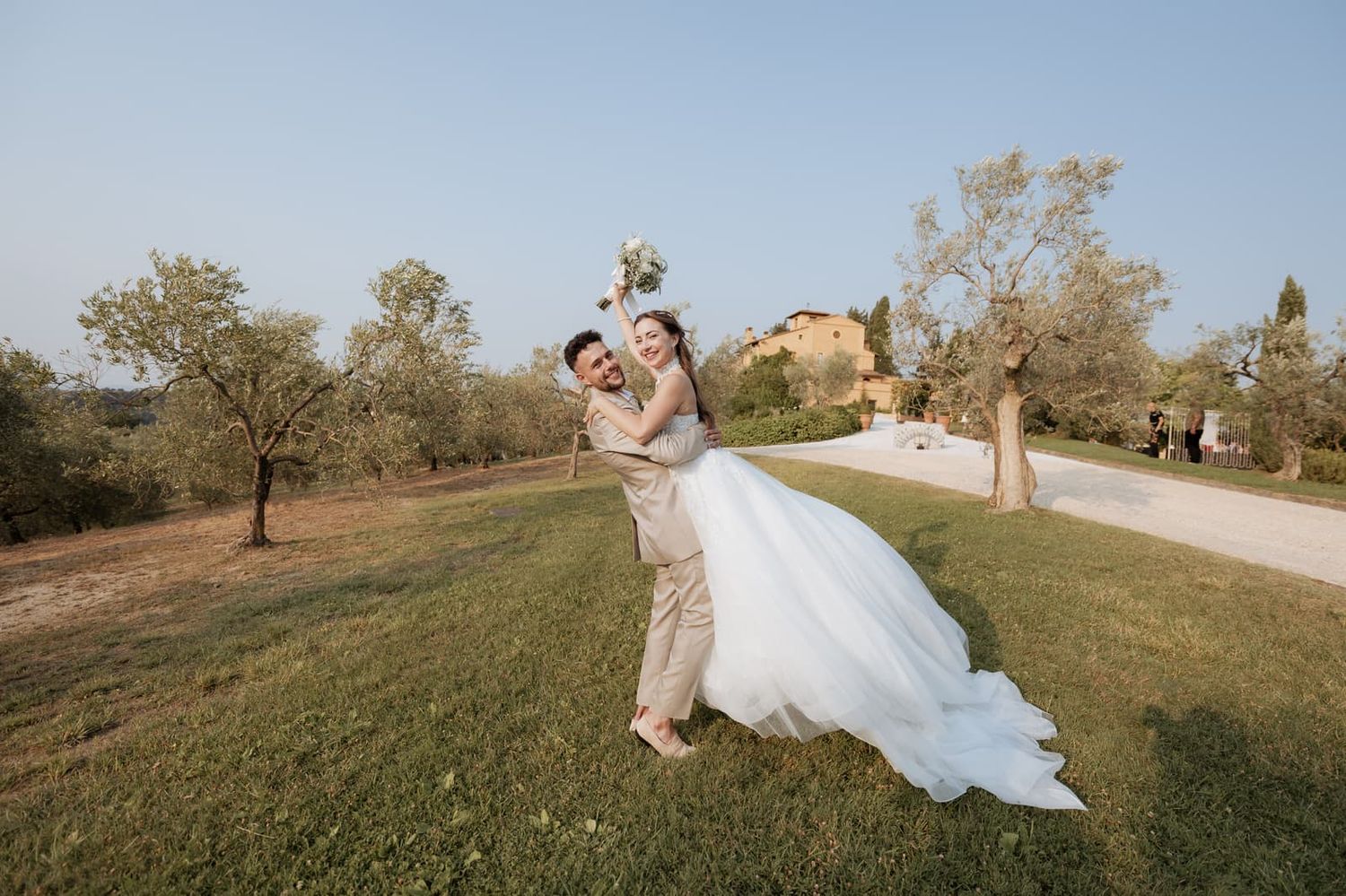Lo sposo solleva la sposa tra gli ulivi al tramonto, Villa il Petriccio, Montespertoli