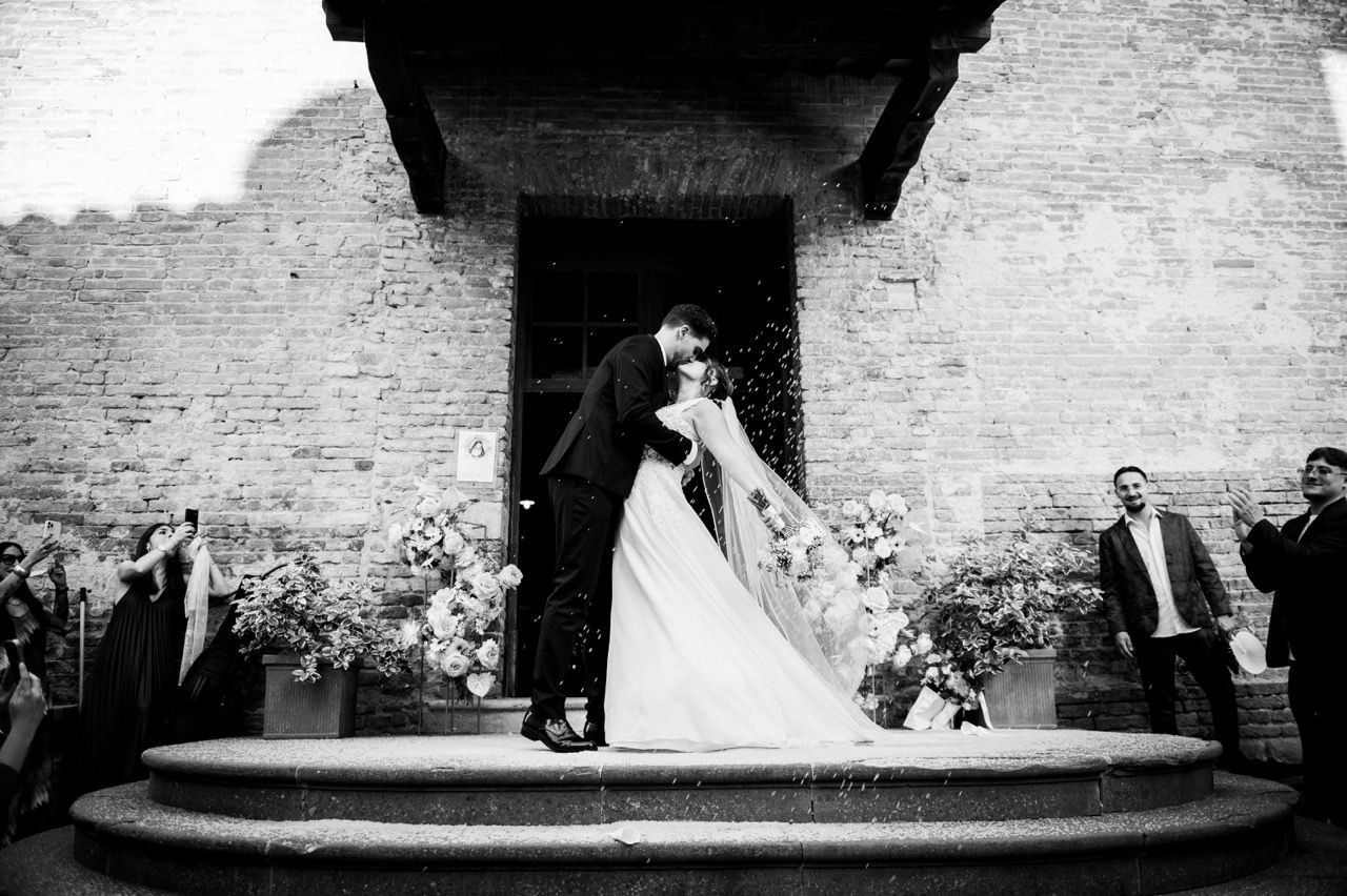 bacio-sposi-esterno-edificio-pietra-bianco-nero-reportage-chiesa-certaldo-alto