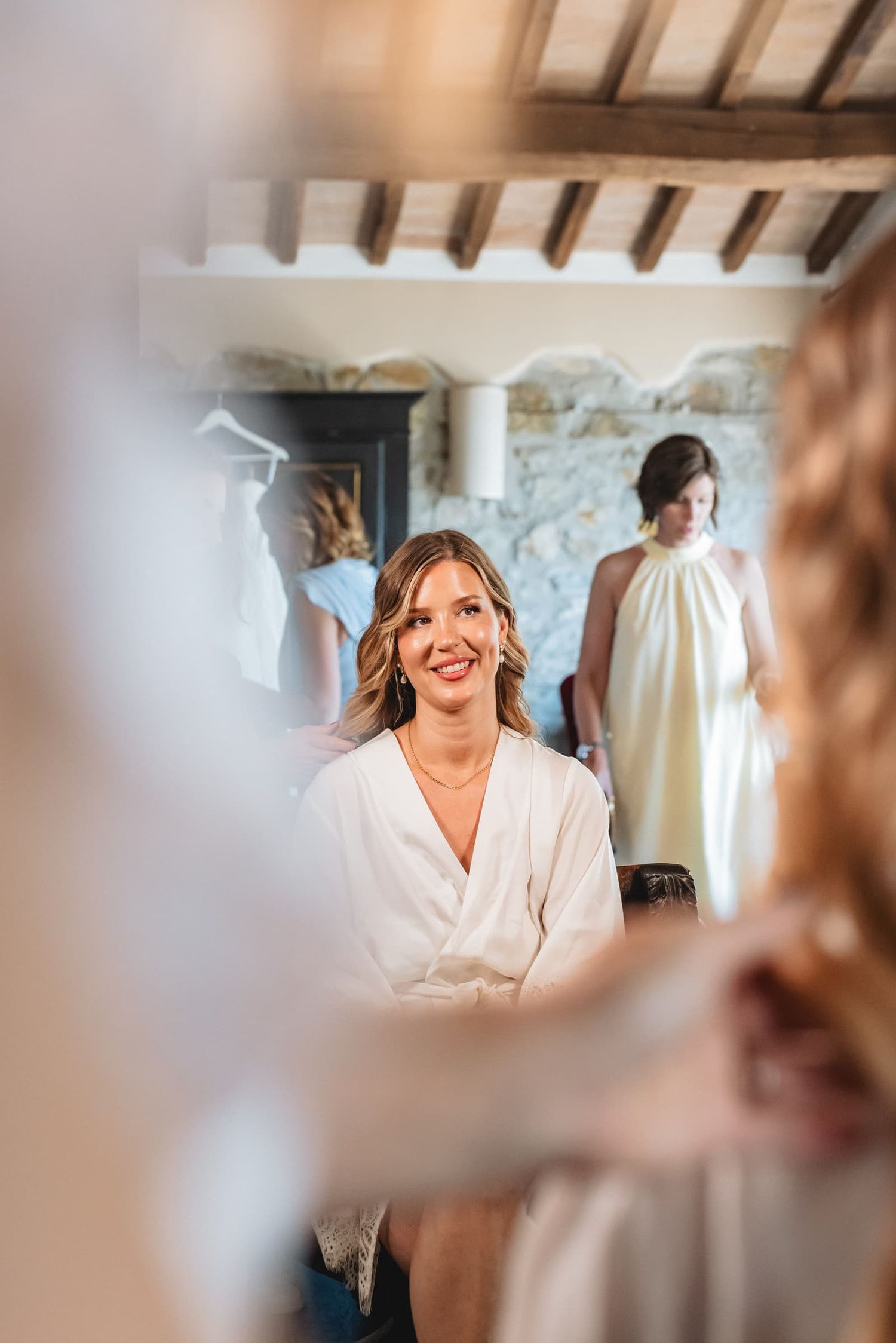 The bride's friends during the preparations in a room with wooden beams, Borgo San Faustino, Umbria