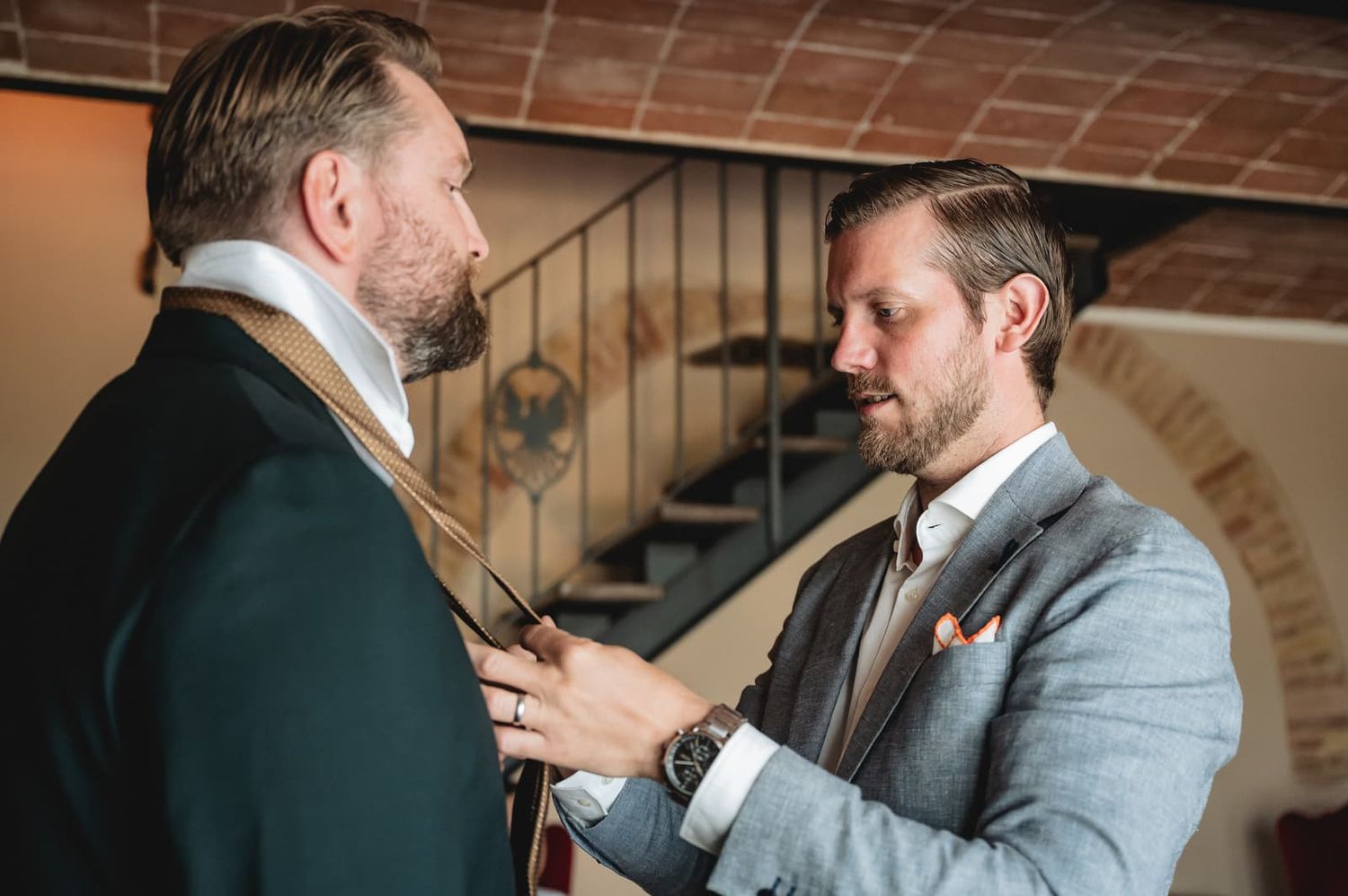 A groomsman helps the groom with his tie at Borgo San Faustino, Orvieto
