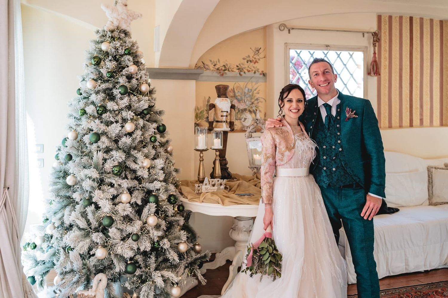 Gli sposi accanto all'albero di Natale durante il ricevimento a Villa il Petriccio, matrimonio a dicembre