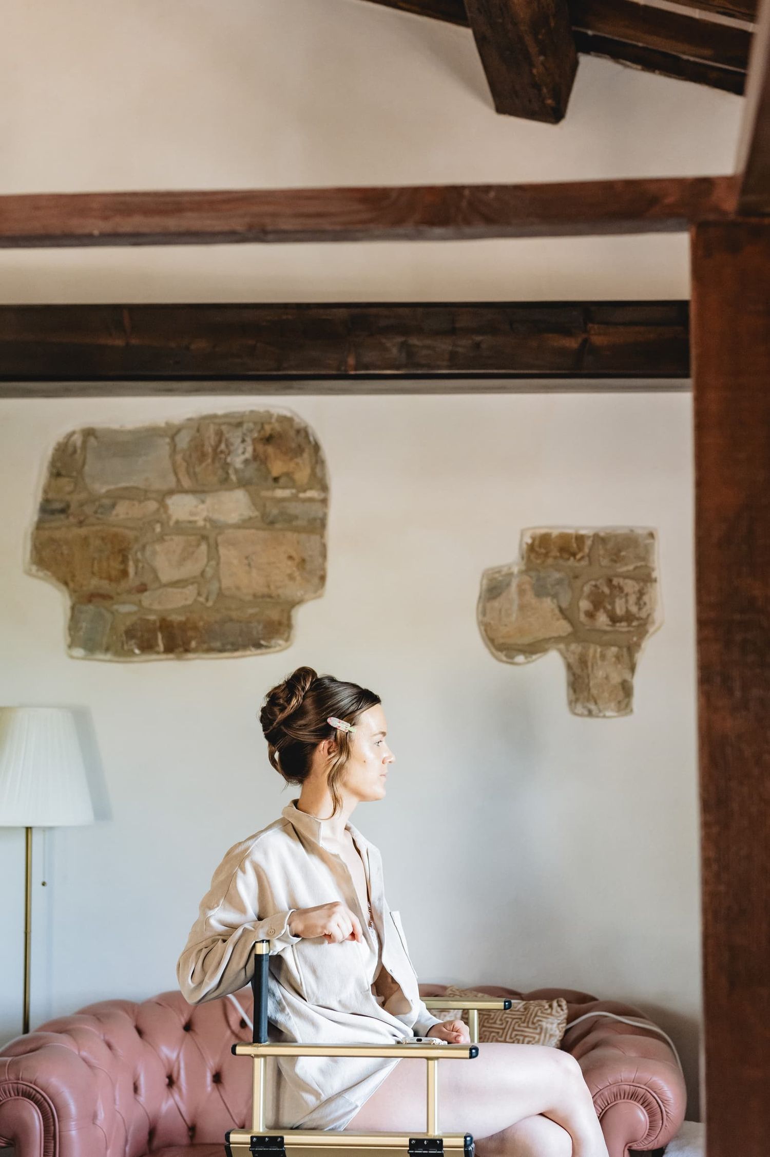 The bride waiting in a room with stone walls and wooden beams, Villa Le Bolli, Tuscany
