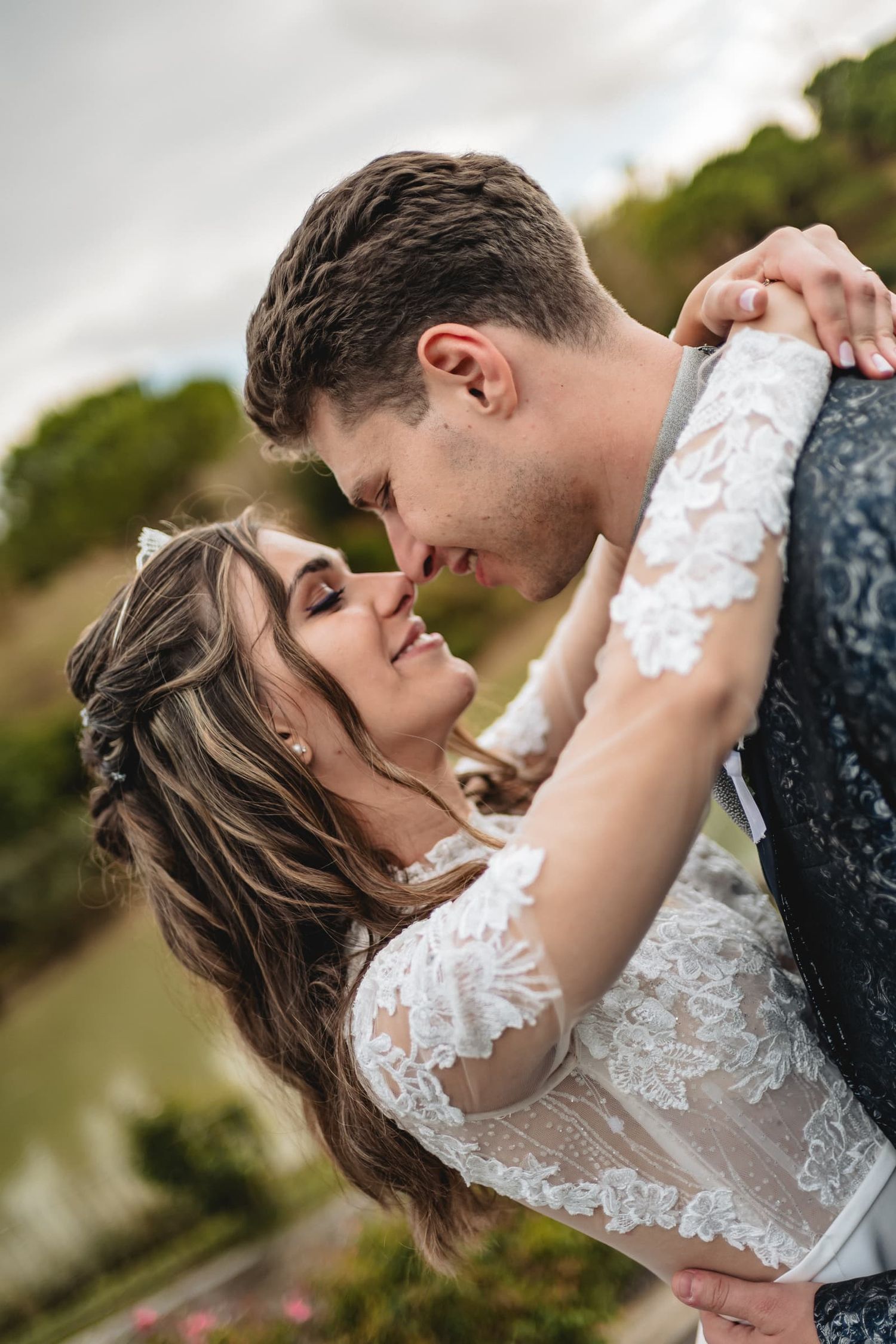 Bacio degli sposi in riva al lago con le colline sullo sfondo, matrimonio di settembre a Il Lago Eventi