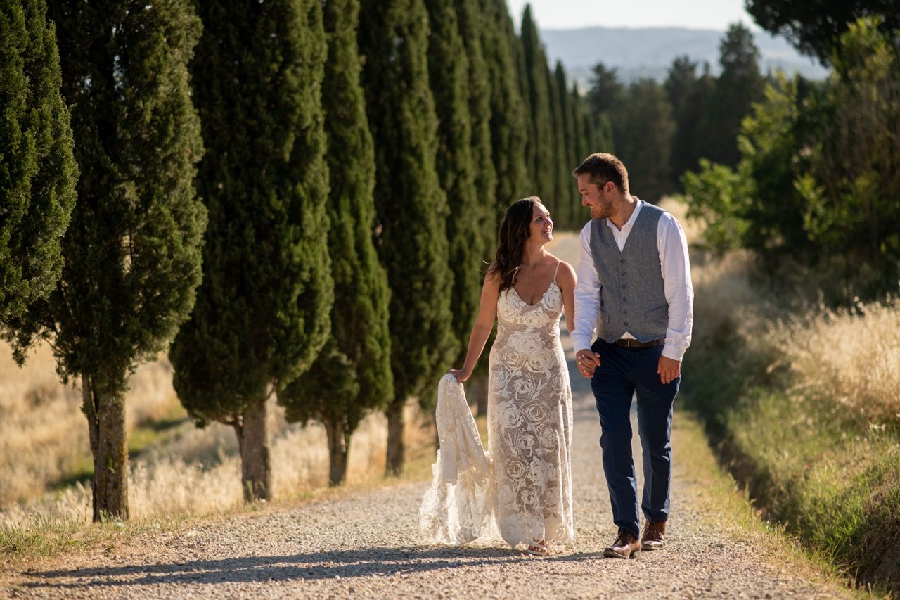 fotografo-matrimonio-toscana-sposi-camminano-viale-cipressi-spontaneo