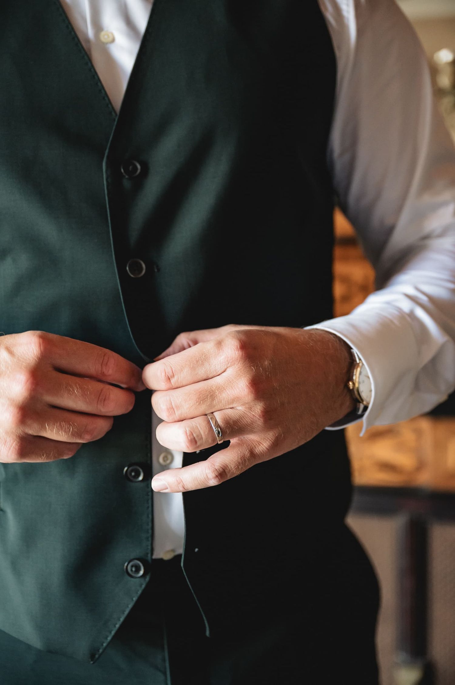 The groom buttoning his waistcoat, wedding at Borgo San Faustino, Umbria