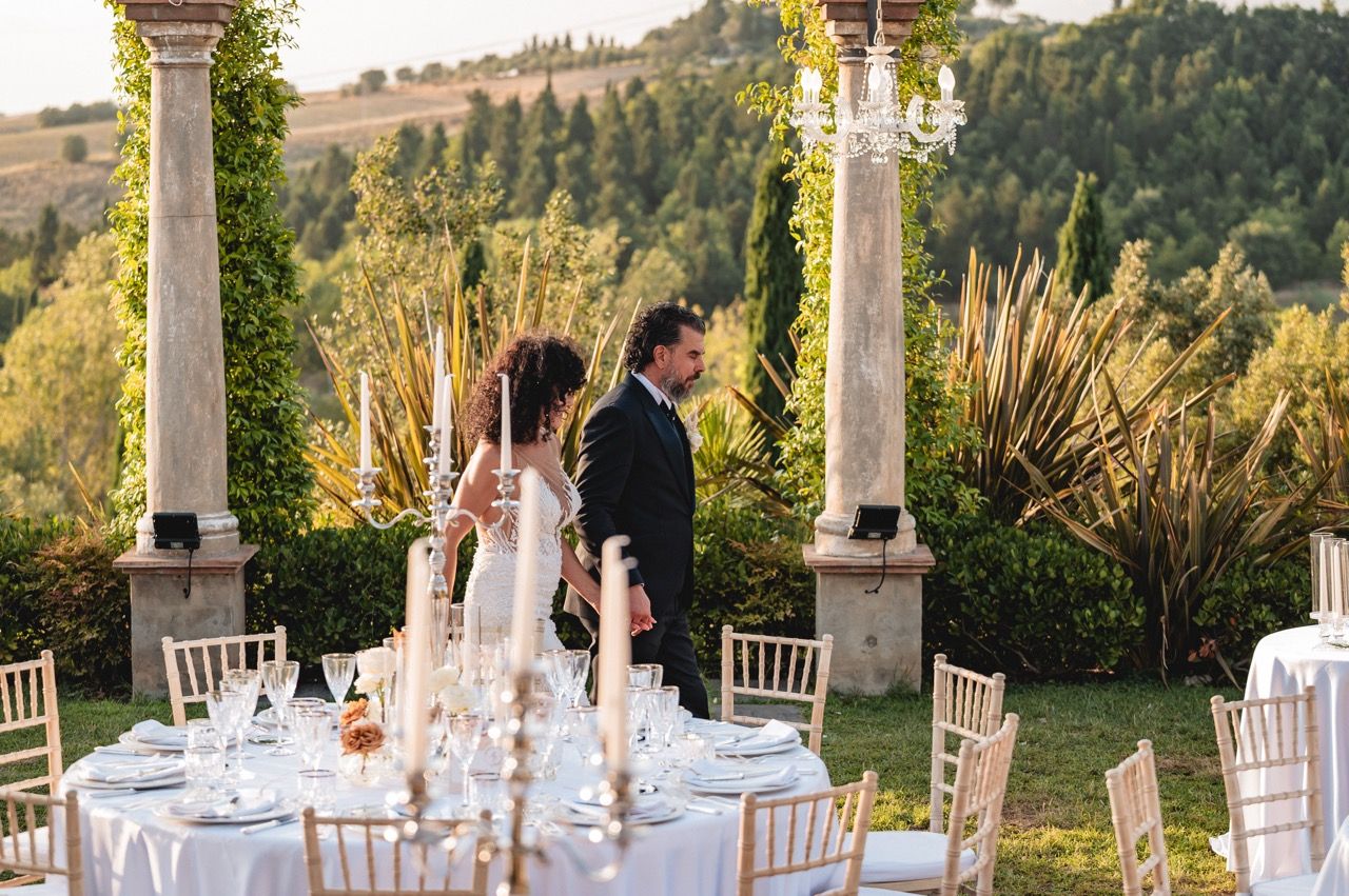 Sposi passeggiano fra i tavoli e allestimenti matrimonio tenuta corbinaia location di lusso