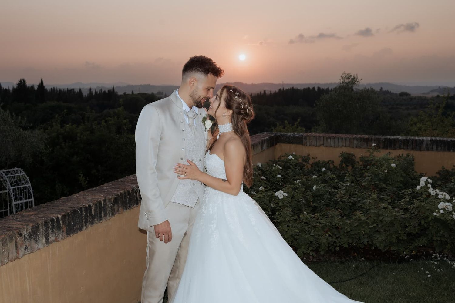 Bacio degli sposi sulla terrazza di Villa il Petriccio con il sole che tramonta sulle colline di Montespertoli