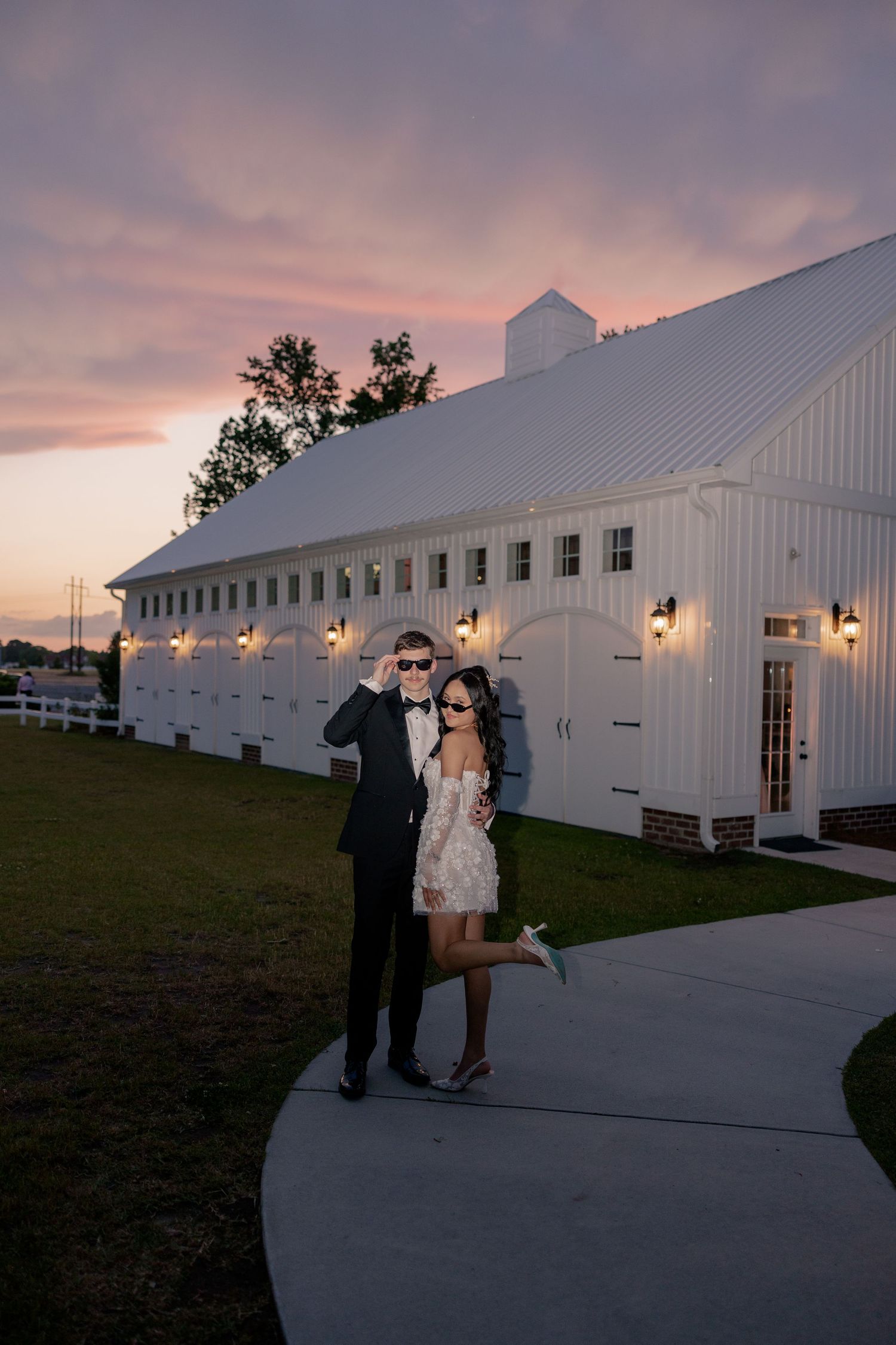 Wedding couple posing outside a grand white building at sunset.