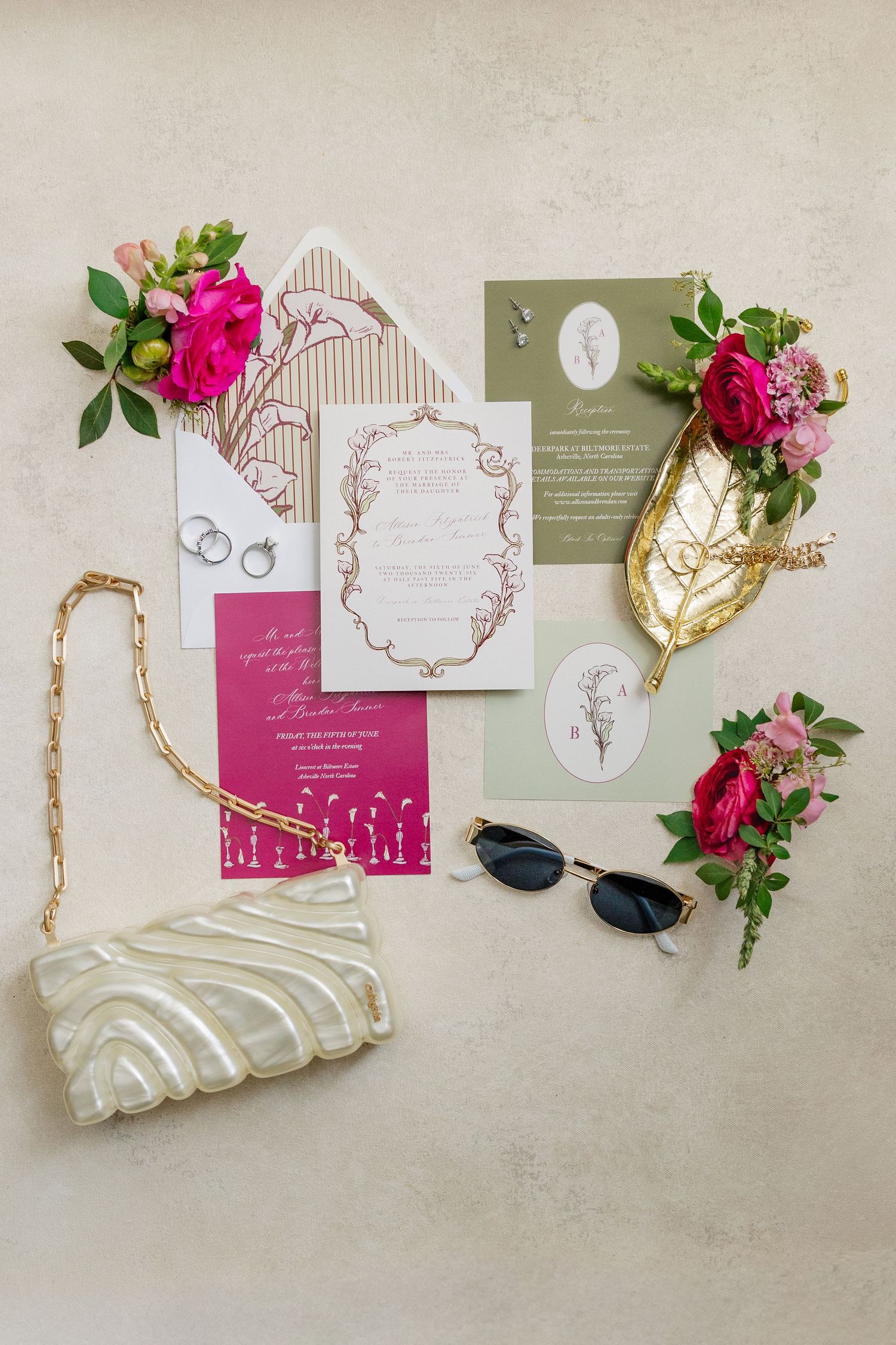 Wedding flat lay featuring floral invitations, rings, white clutch, sunglasses, and pink peonies on a neutral background.