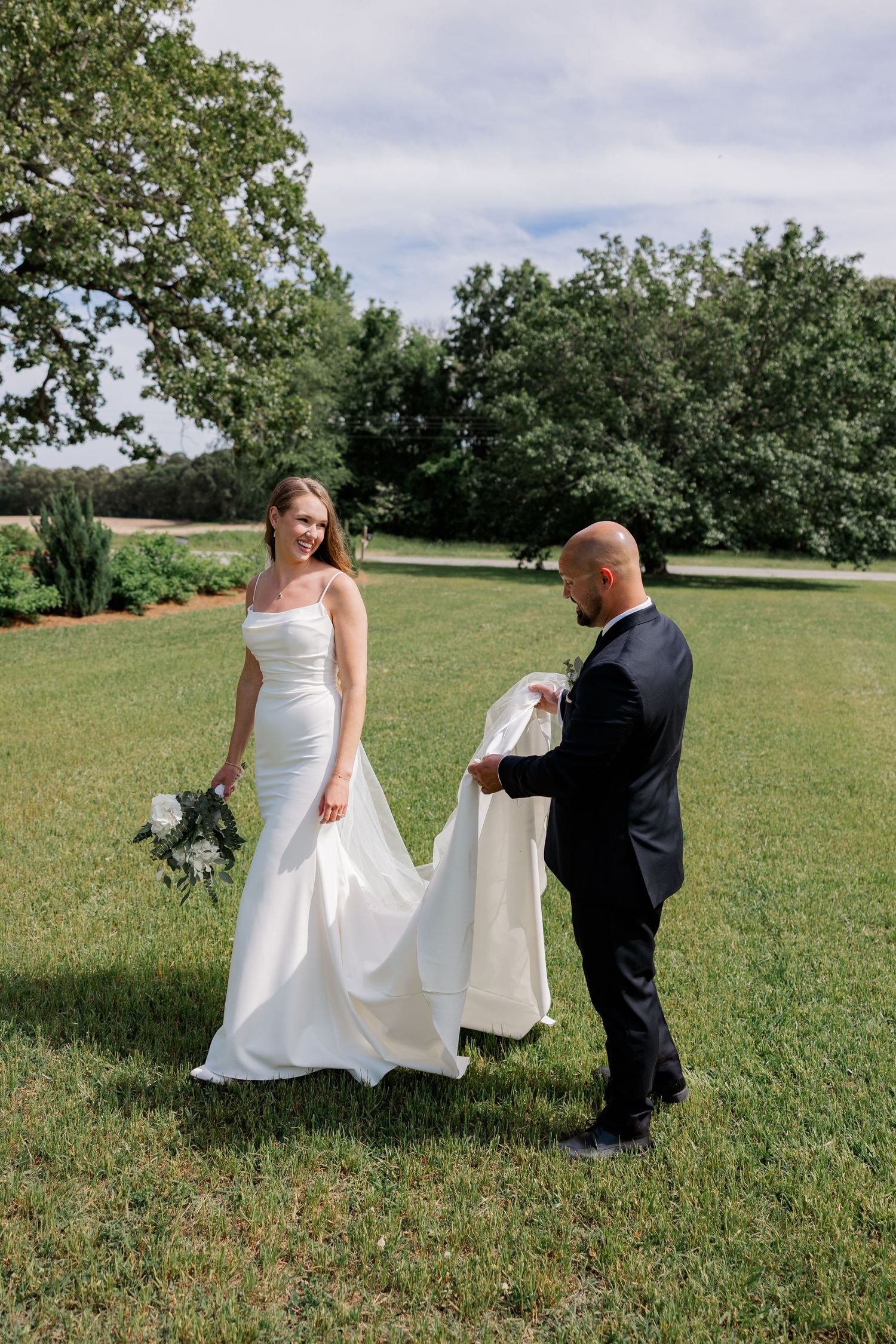 Wedding photography session on green grass with white dress and formal attire.