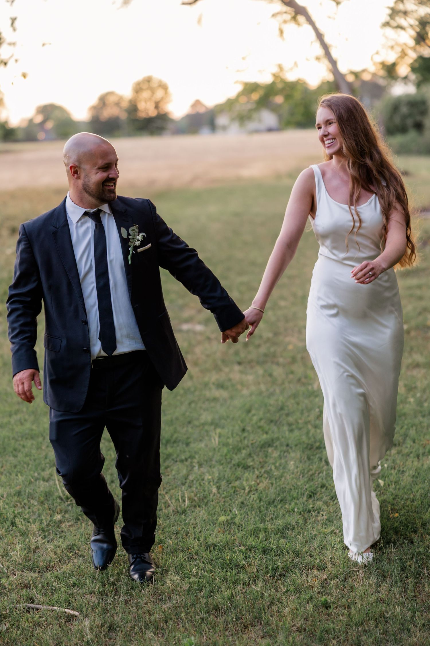 Candid shots of couple running and laughing together in a grassy field.