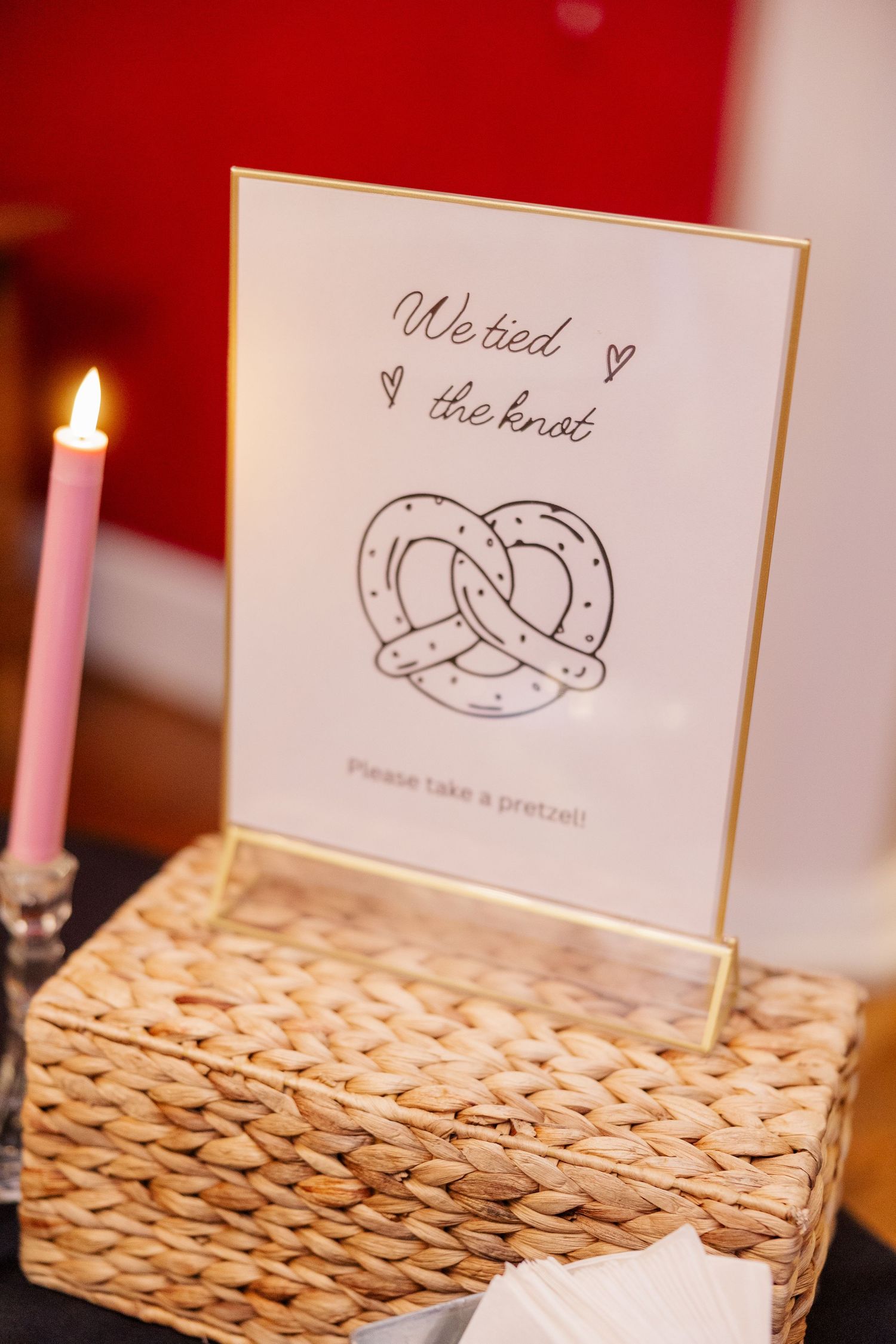 Wedding place cards with horseshoe designs displayed on woven placemats with lit candles.