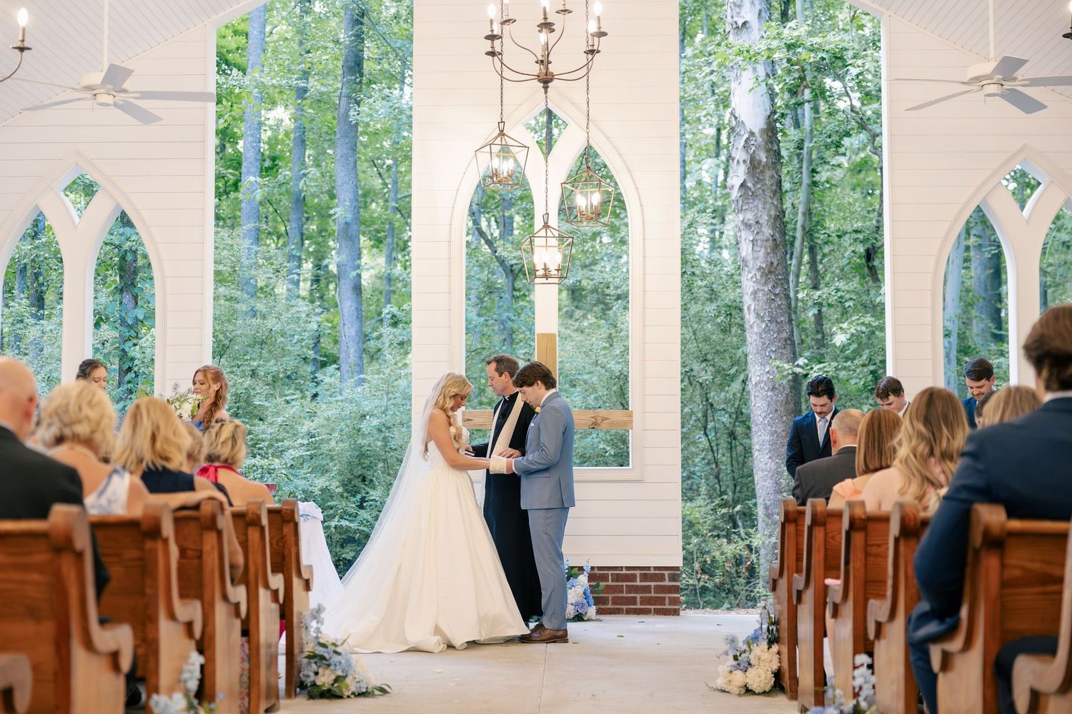 Bride and groom exchange vows at the altar of a sunlit chapel ceremony.